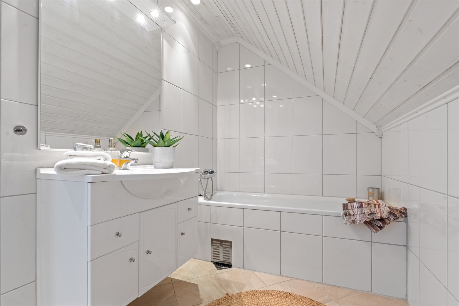 Badet i 2.etasje er også flislagt og har varme i gulvet. Her er det baderomsinnredning, innbygget badekar og veggmontert toalett. Galleribilde