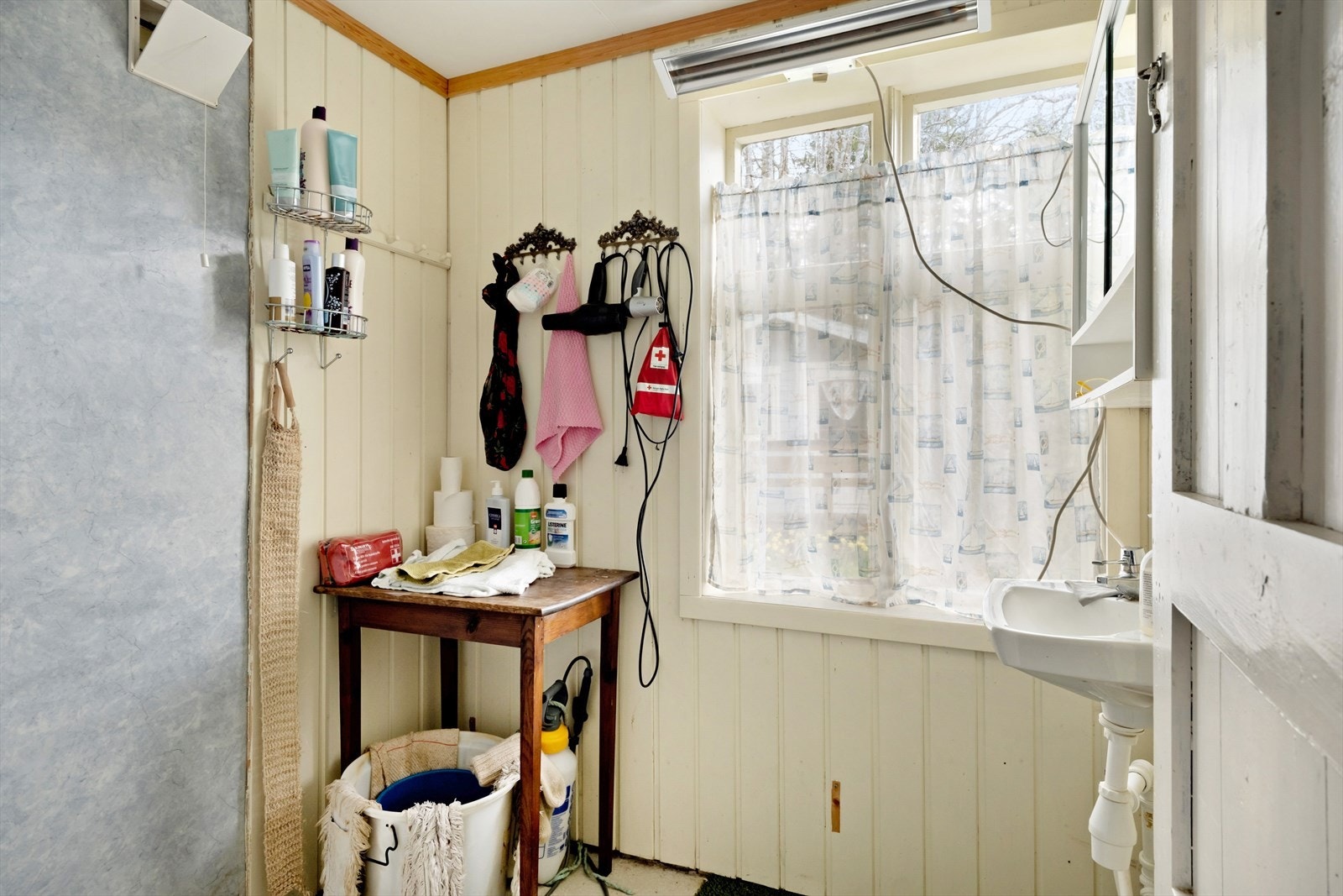 I huset er det eit enkelt bad med dusj og servant. Galleribilde
