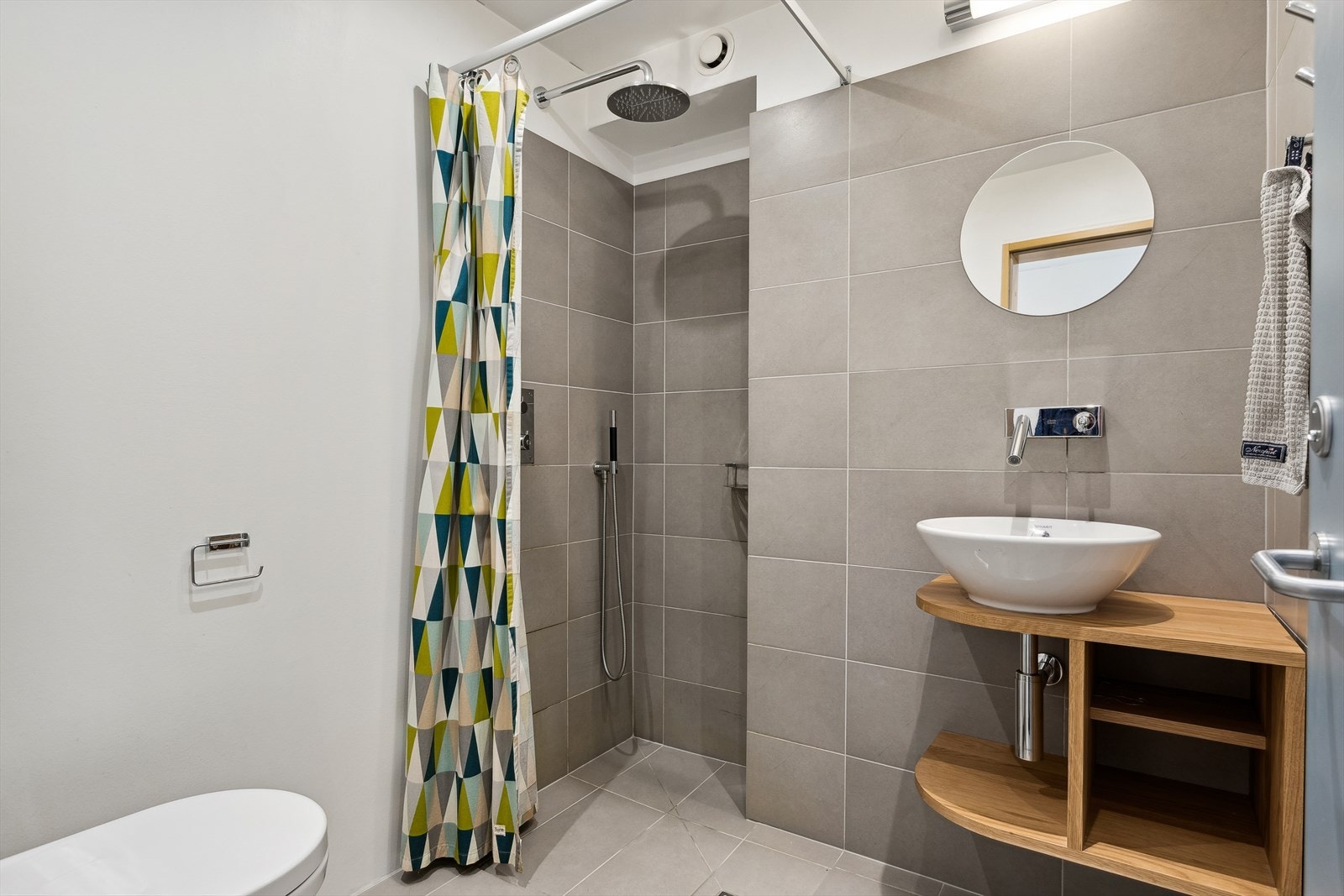 Innredningen består av toppmontert servant på trefarget benkeseksjon. På badet er det også speil med overlys samt veggmontert toalett Galleribilde