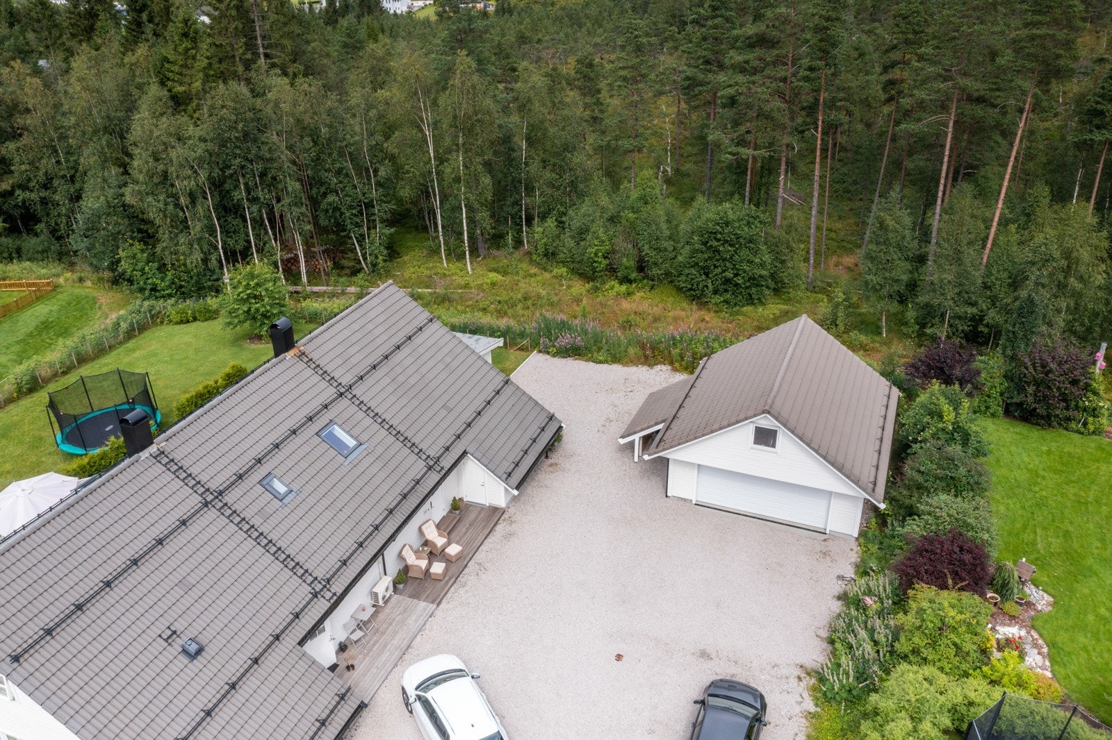 Romslig tunplass med grusdekke på framsida av boligen Galleribilde