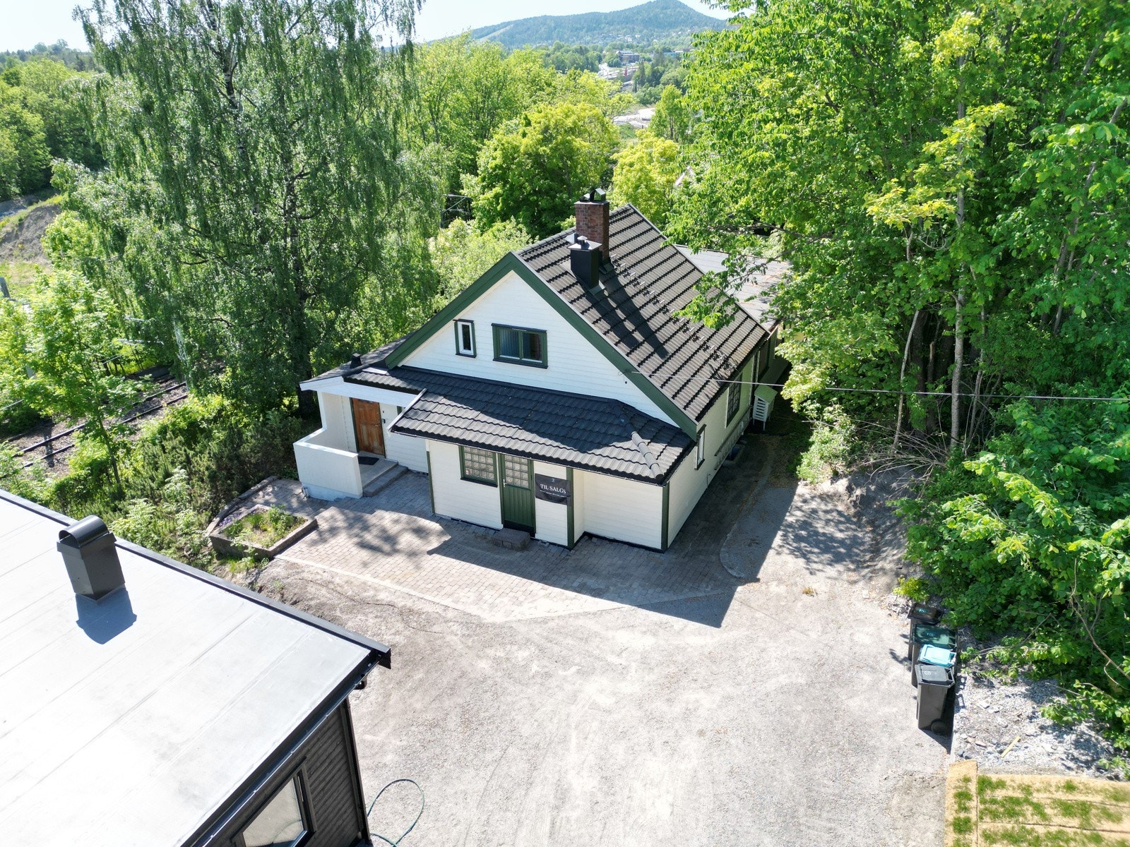 Stor gårdsplass med flere biloppstillingsplasser. Boligen ligger flott til med flere usjenerte boltreplasser i hagen. Galleribilde