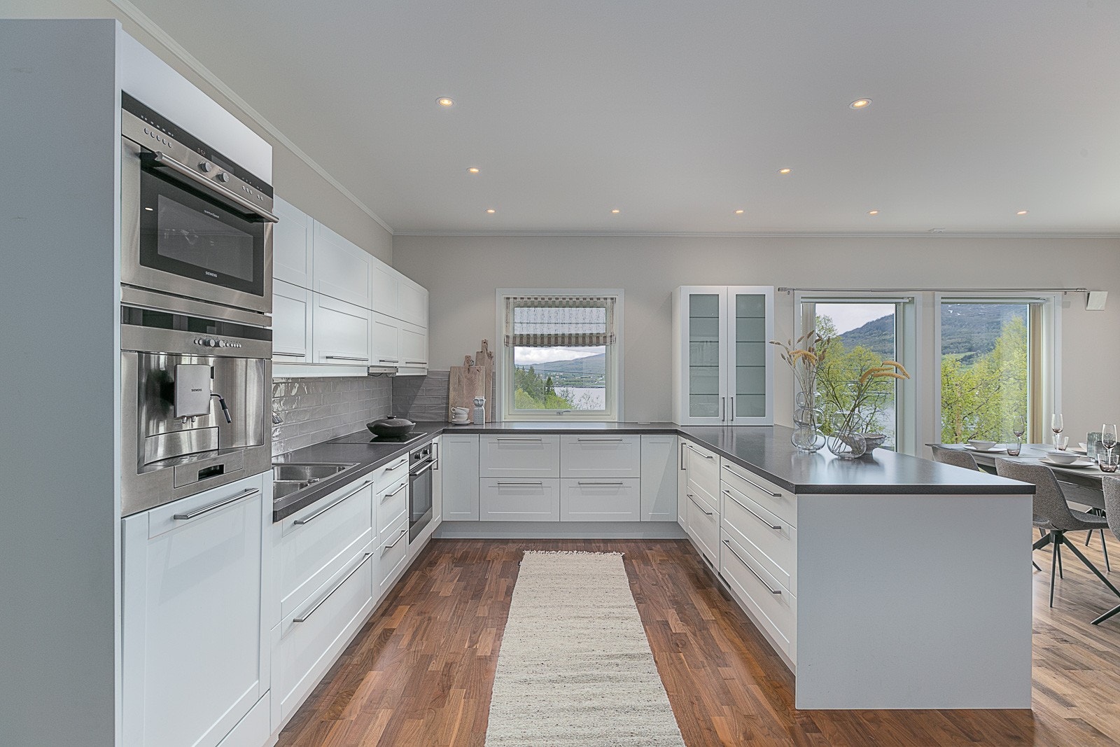 Pent og gjennomført kjøkken med integrerte hvitevarer. Galleribilde