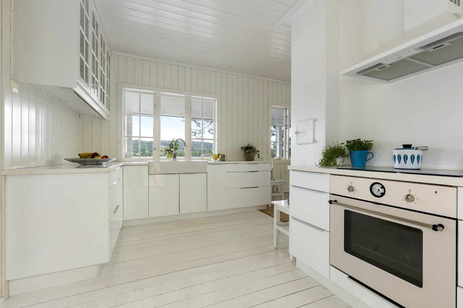 Kjøkken med flislagt benkeplate, vask med to kummer av porselen, og integrert komfyr med platetopp. Galleribilde