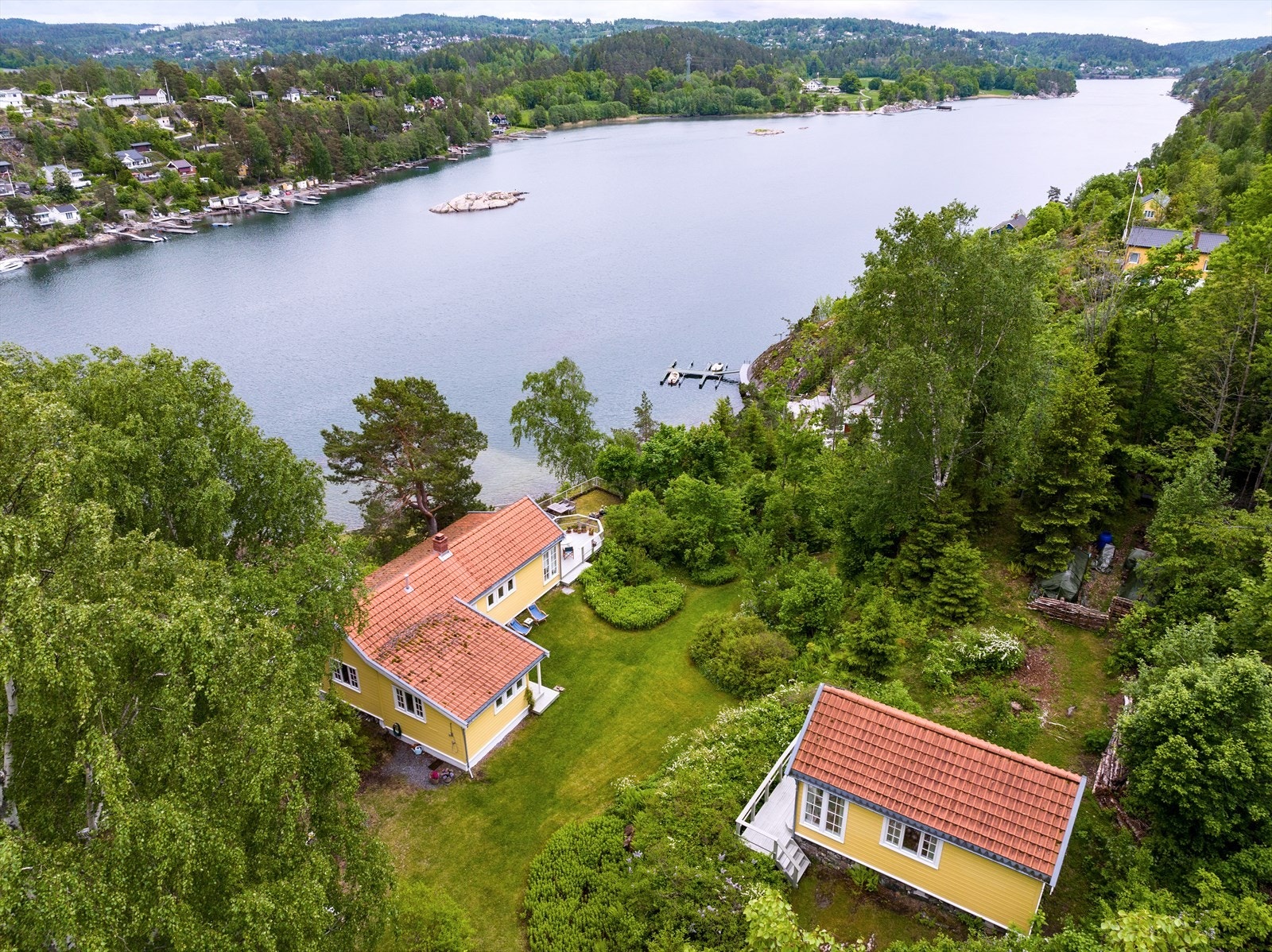 Felles båthus nede i venstre bildekant, båtplass på bryggen midt i bildet. Galleribilde