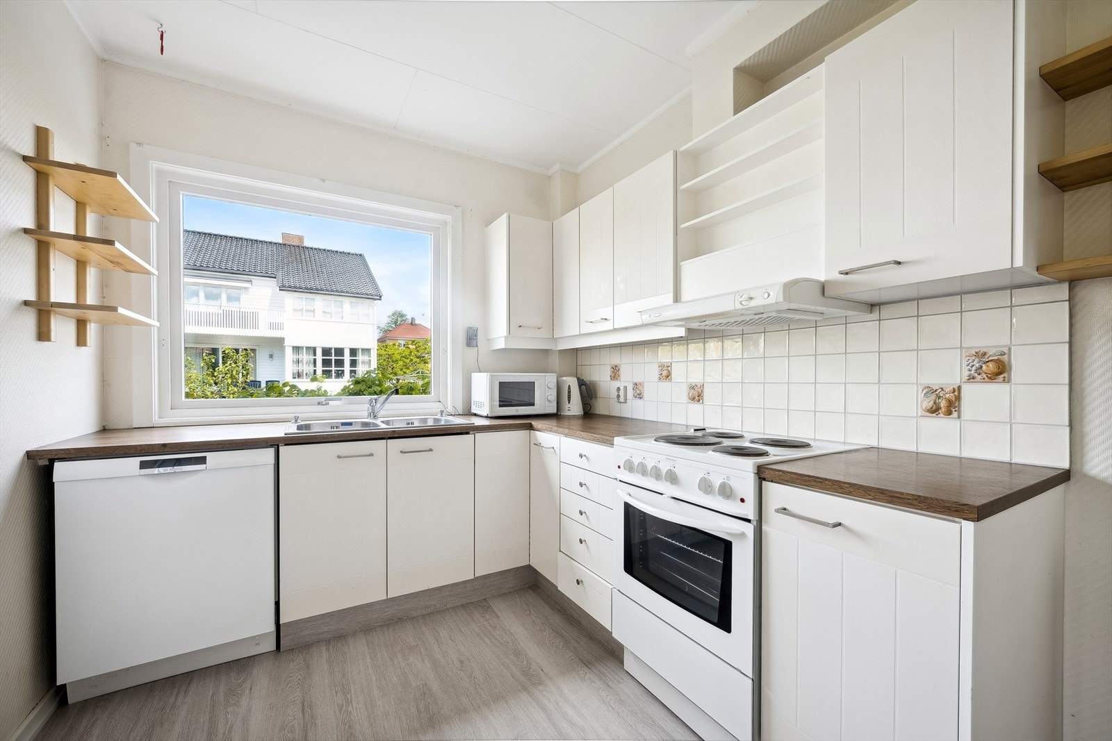 Kjøkken 1.etg. Velholdt innredning med trefinerte glatte hvite fronter. Laminat benkeplate. Opplegg for oppvaskmaskin. Galleribilde
