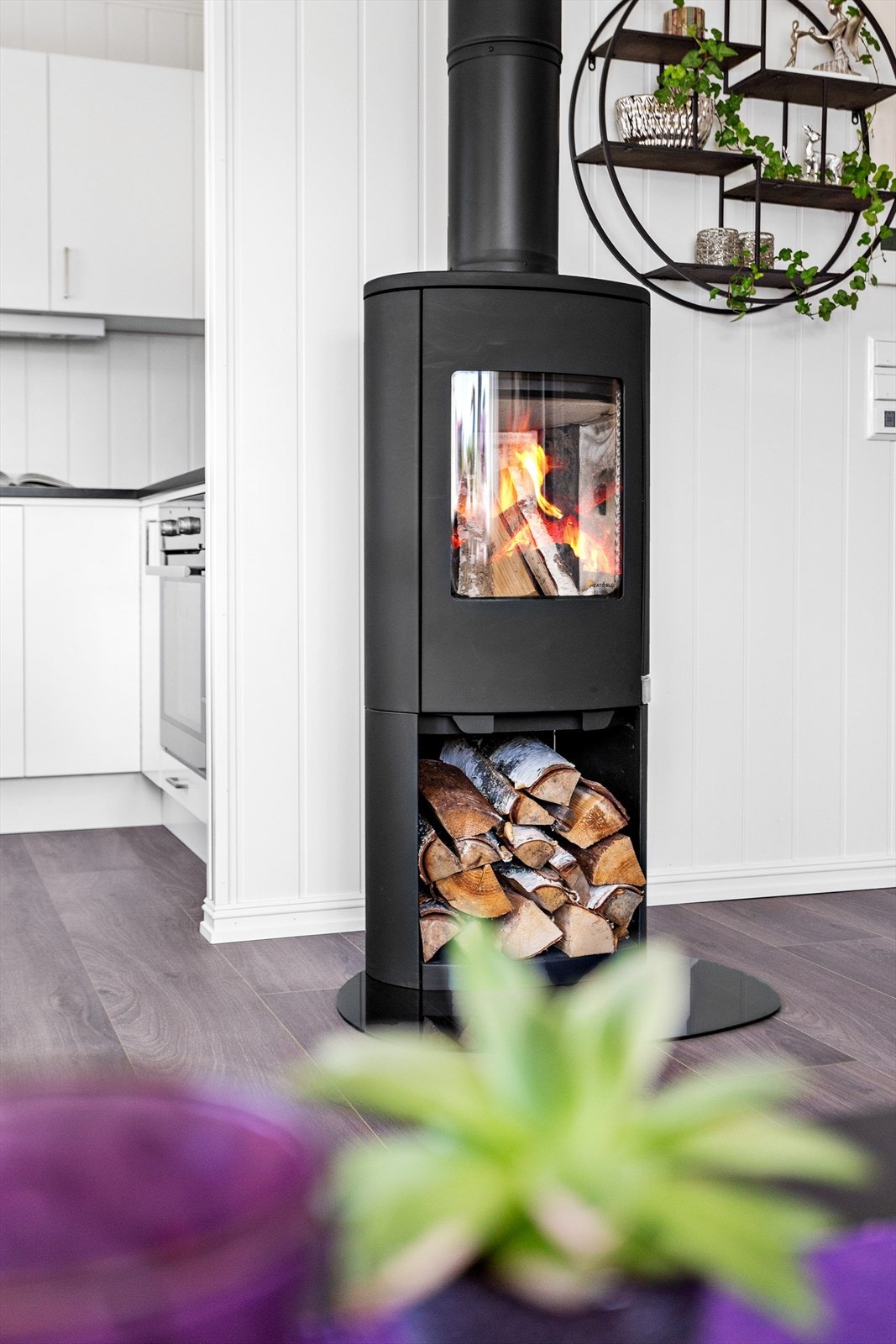 Sentralt i rommet er en moderne peisovn som bidrar til ekstra hygge og varme. Galleribilde