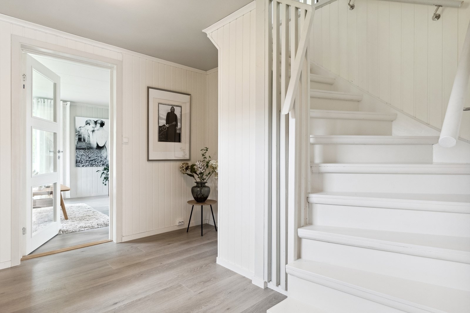 Fra trappegangen i første etasje er det dør med glass inn til stuen. Galleribilde