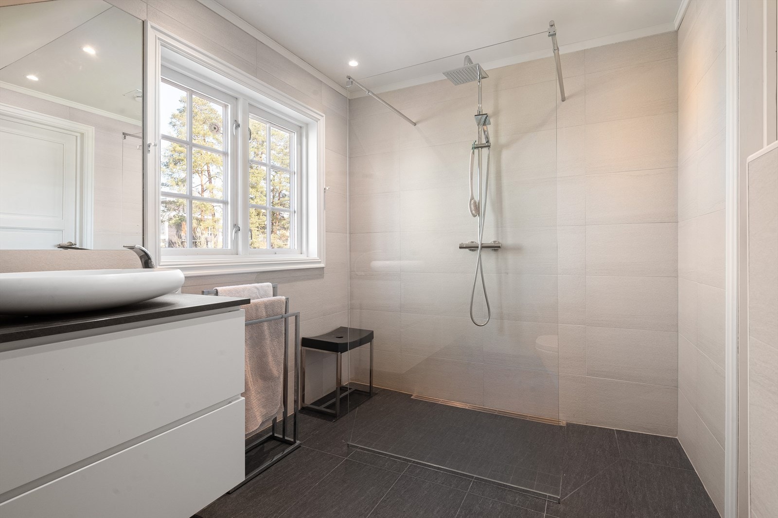 Mørkegrå-laminert benkeplate med overmontert hvit enkel servant i kompositt med ettgreps blandebatteri i rustfritt stål. Galleribilde