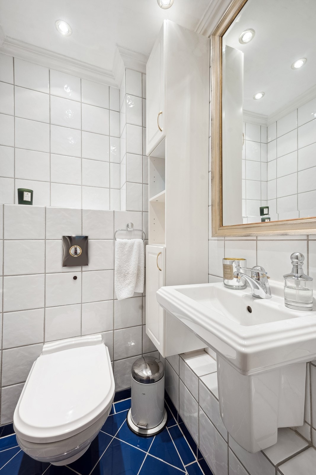 Separat toalettrom med servant, vegghengt toalett og høyskap som ligger vegg i vegg med badet. Galleribilde