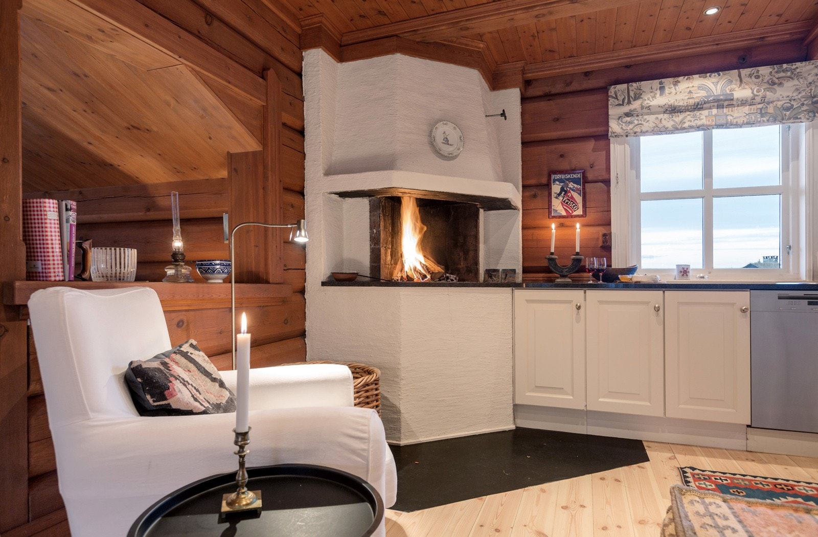 En flott åpen peis på kjøkkenet skaper god stemning og varme i rommet Galleribilde