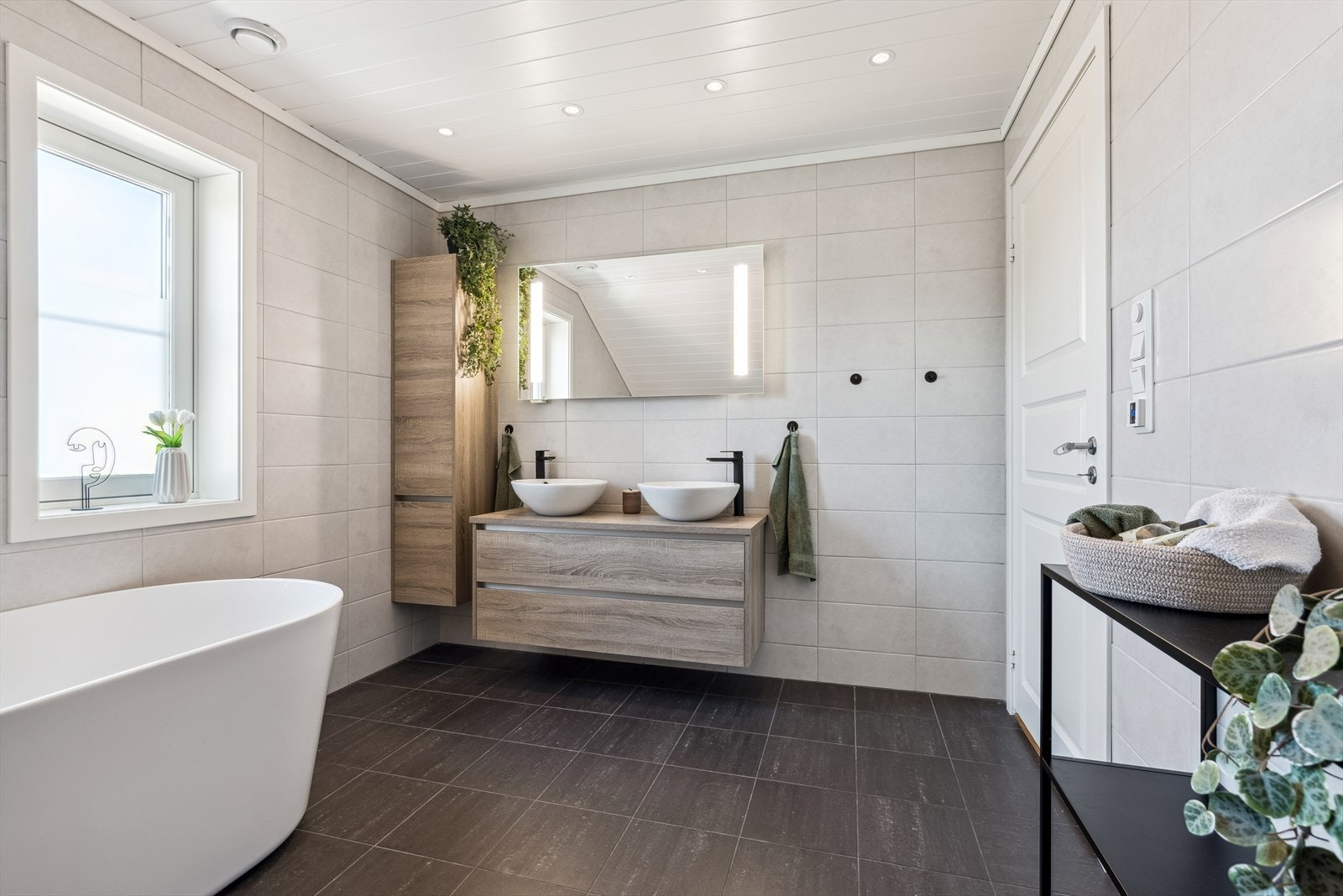 Badet er helfliset med varmekabler i gulv, innholdende badekar, wc og dobbel vask. Galleribilde