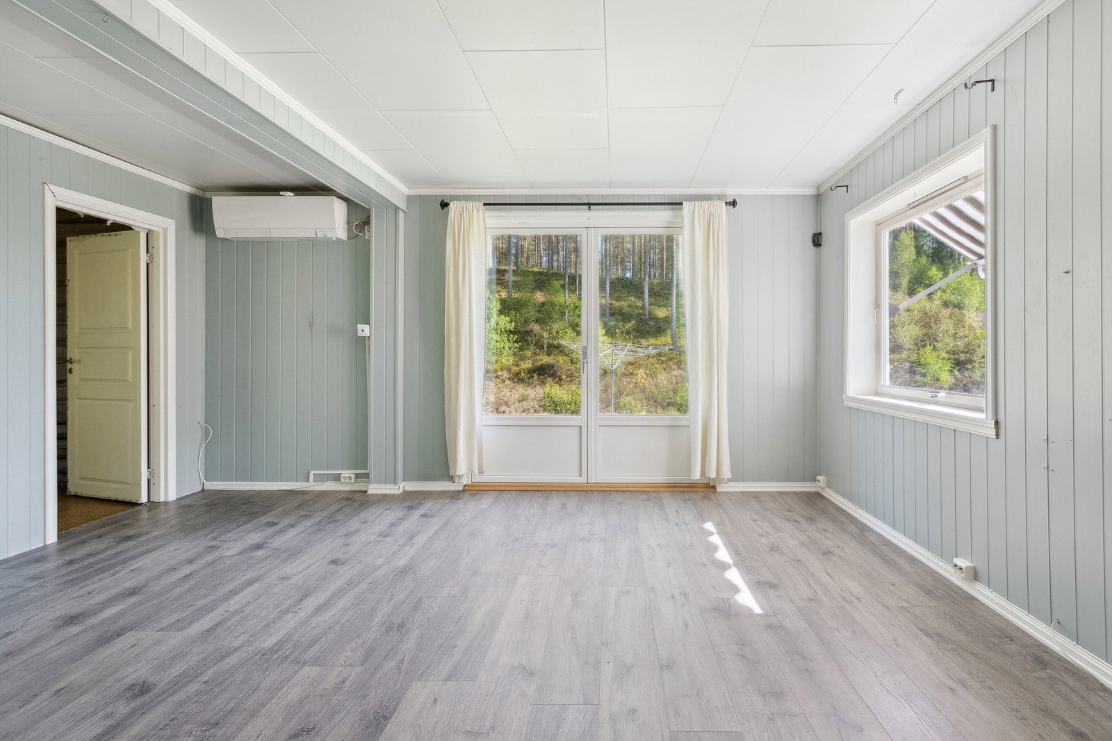 Fin stue med utgang til terreng. I stua er det en luft-luft varmepumpe Galleribilde
