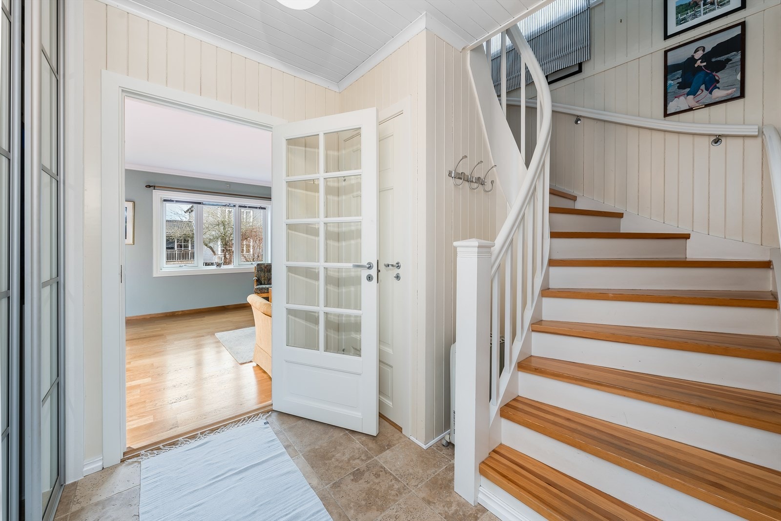 Videre inn kommer du inn i gangen hvor det er malt tretrapp fra 2007 opp til 2. etasje. I gangen er det en praktisk skyvedørsgarderobe for oppbevaring. Galleribilde