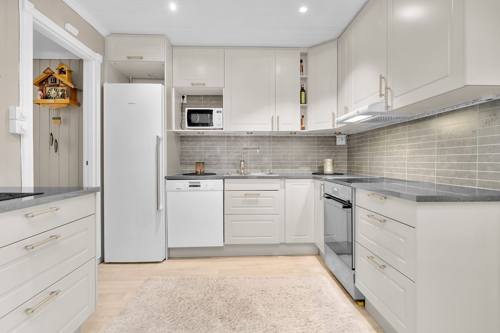 i 1. etasje er det et pent kjøkken med Kitchenboard på vegg mellom benk og overskap. Galleribilde