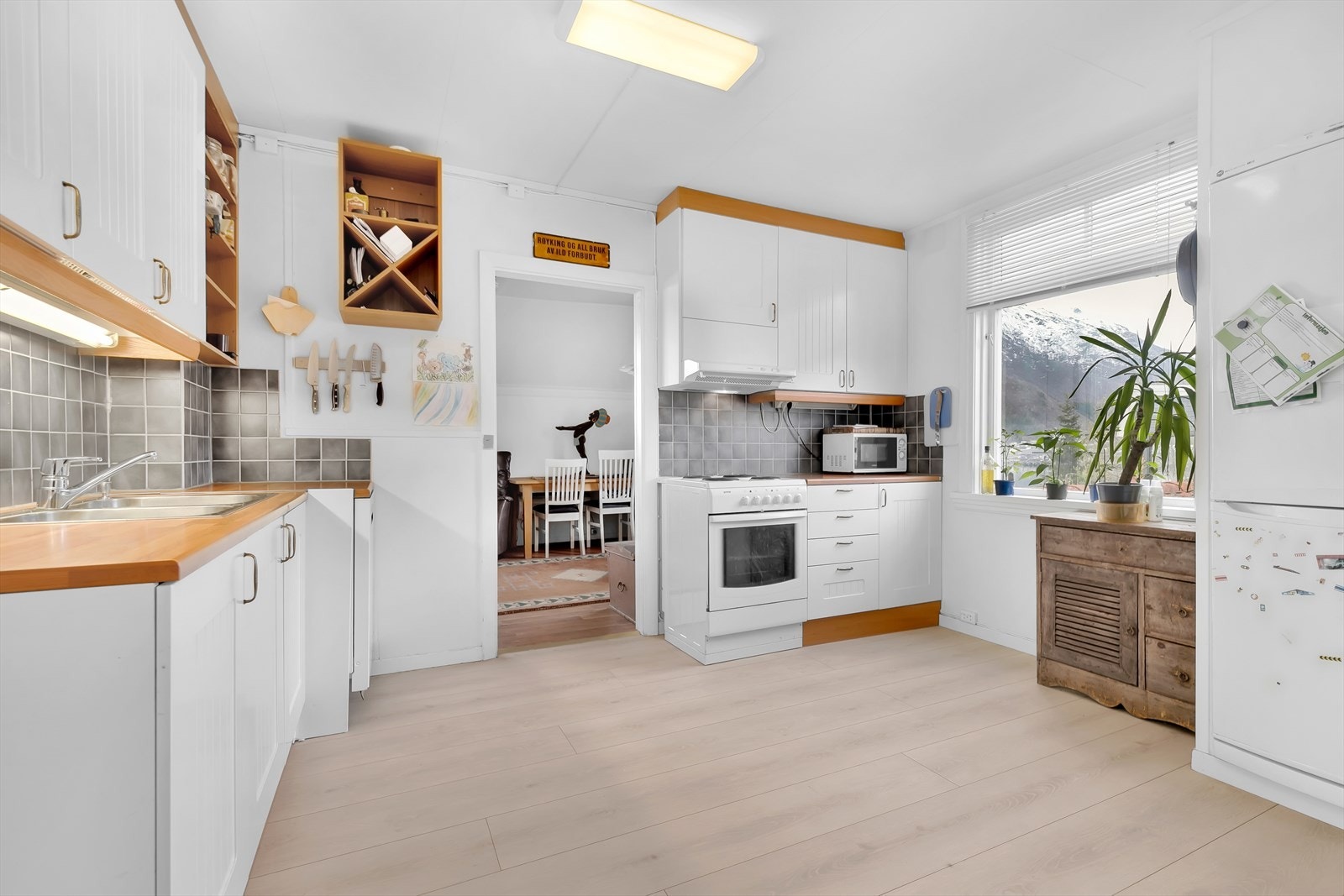 Lys kjøkkeninnredning med keramiske fliser over kjøkkenbenk Galleribilde