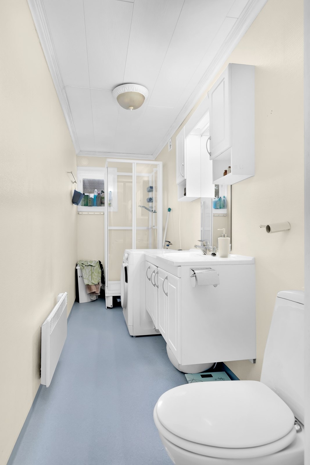 Badet har dusjkabinet og opplegg for vaskemaskin Galleribilde