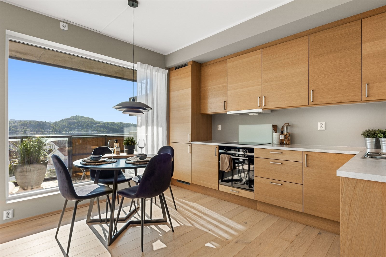 Stilrent kjøkken i eik med integrerte hvitevarer og god skapplass Galleribilde