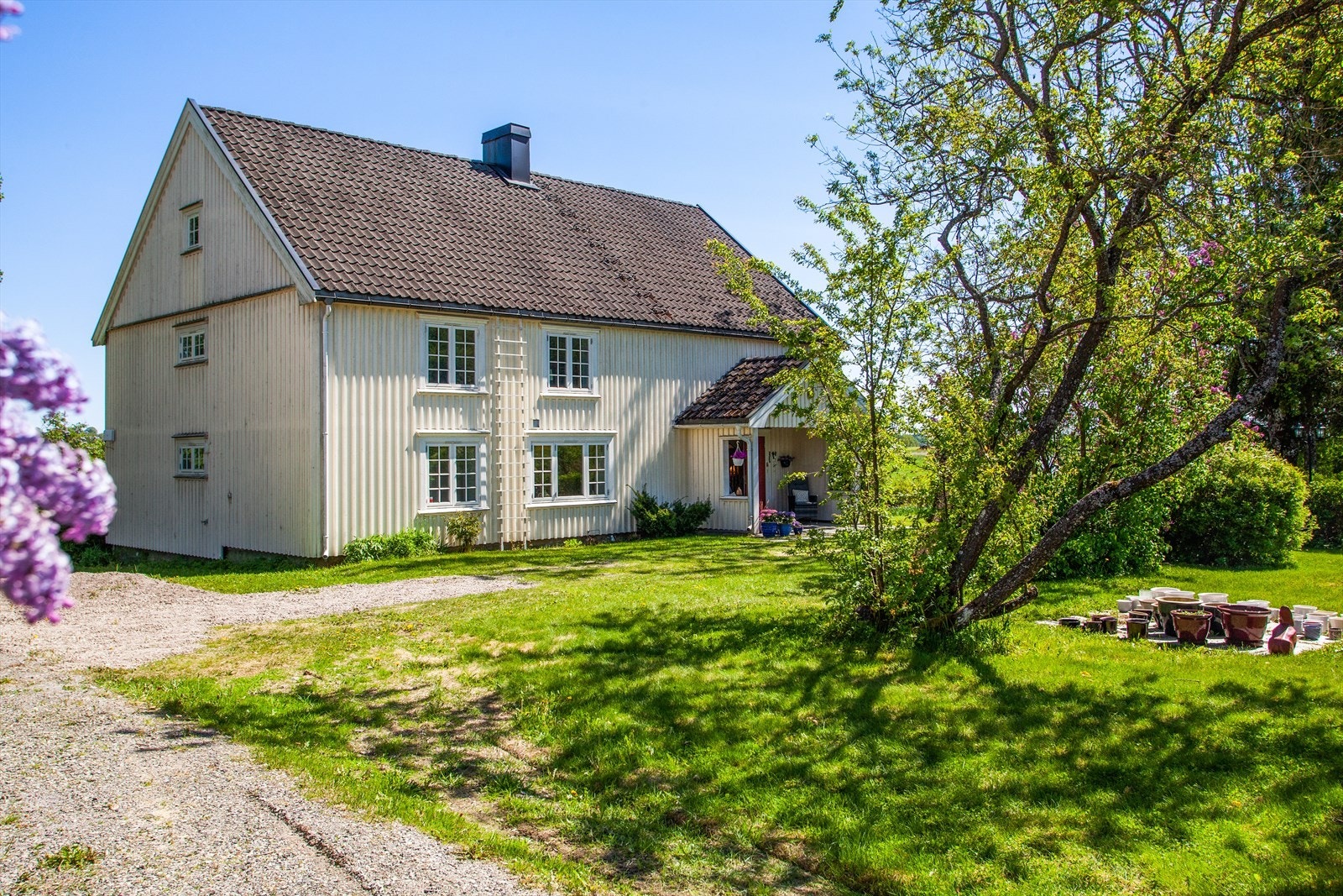 Stort gruset gårdstun med god plass til parkering av biler. Galleribilde