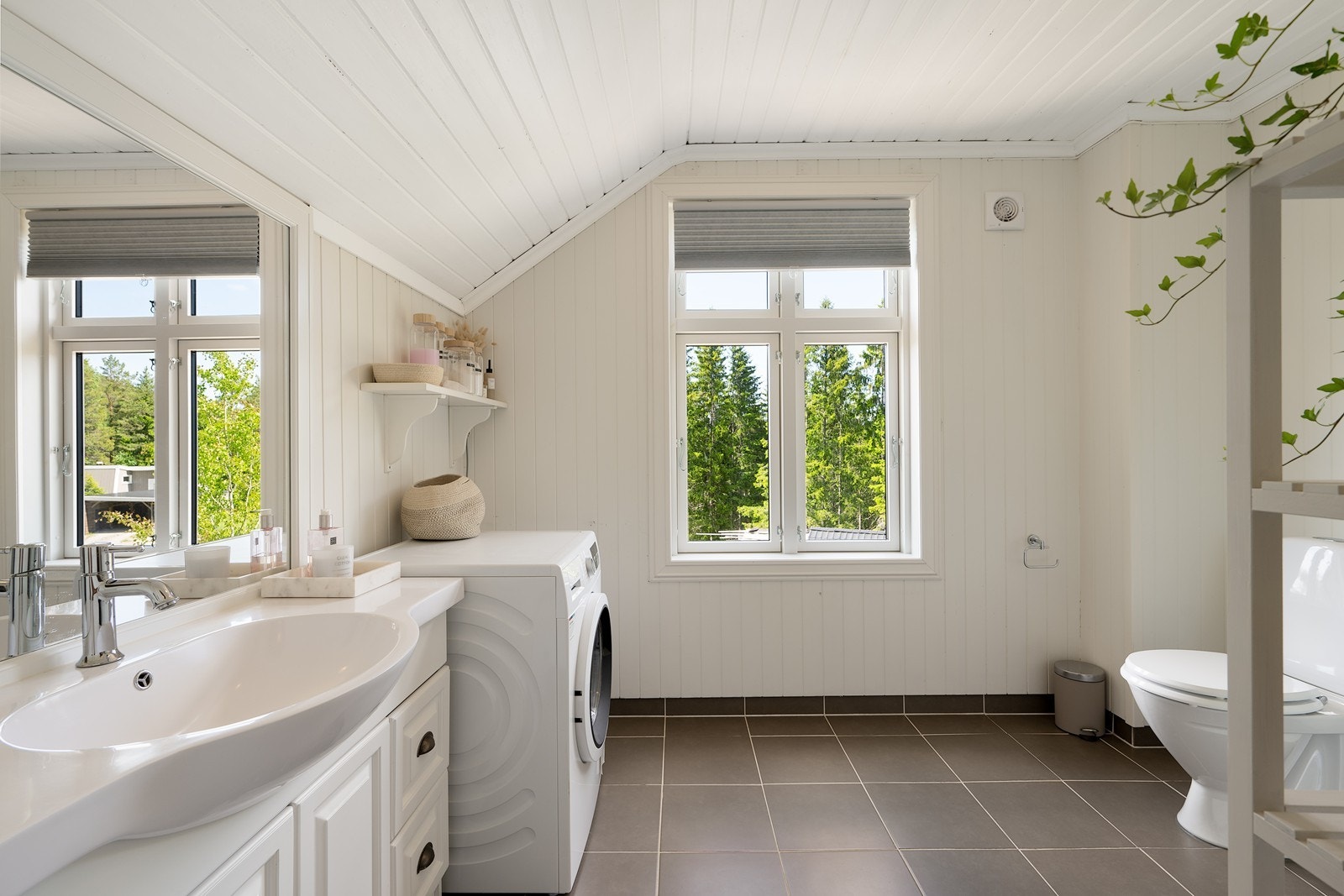Badet er lyst og tiltalende og har innredning med heldekkende servant over hvitt baderomsmøbel,og innebygget speil. Galleribilde