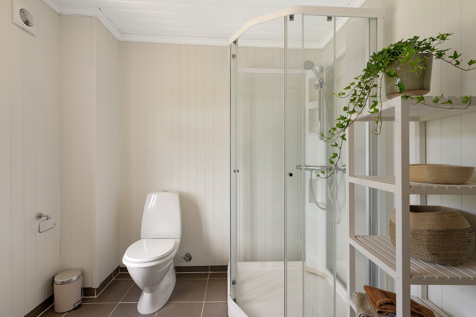 Videre har badet gulvfestet toalett, dusjkabinett, opplegg for vaskemaskin og lun gulvvarme. Galleribilde