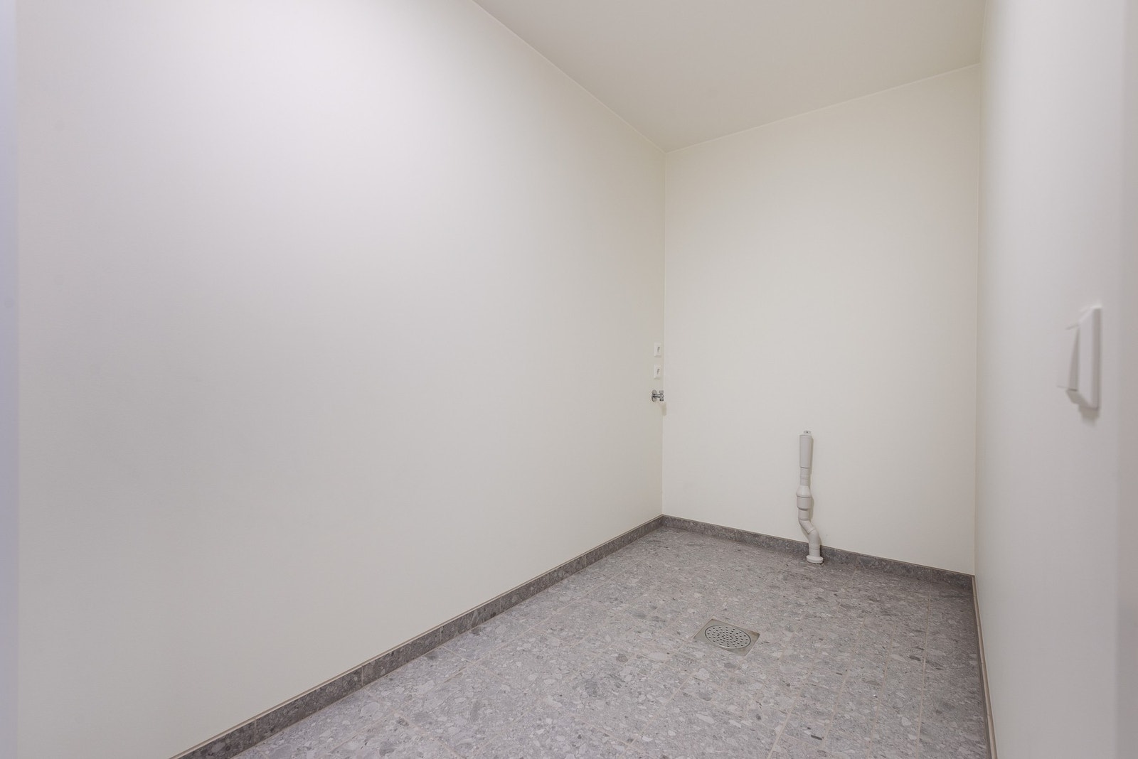 Teknisk rom med opplegg for vaskemaskin. Det er sluk i gulvet. Galleribilde