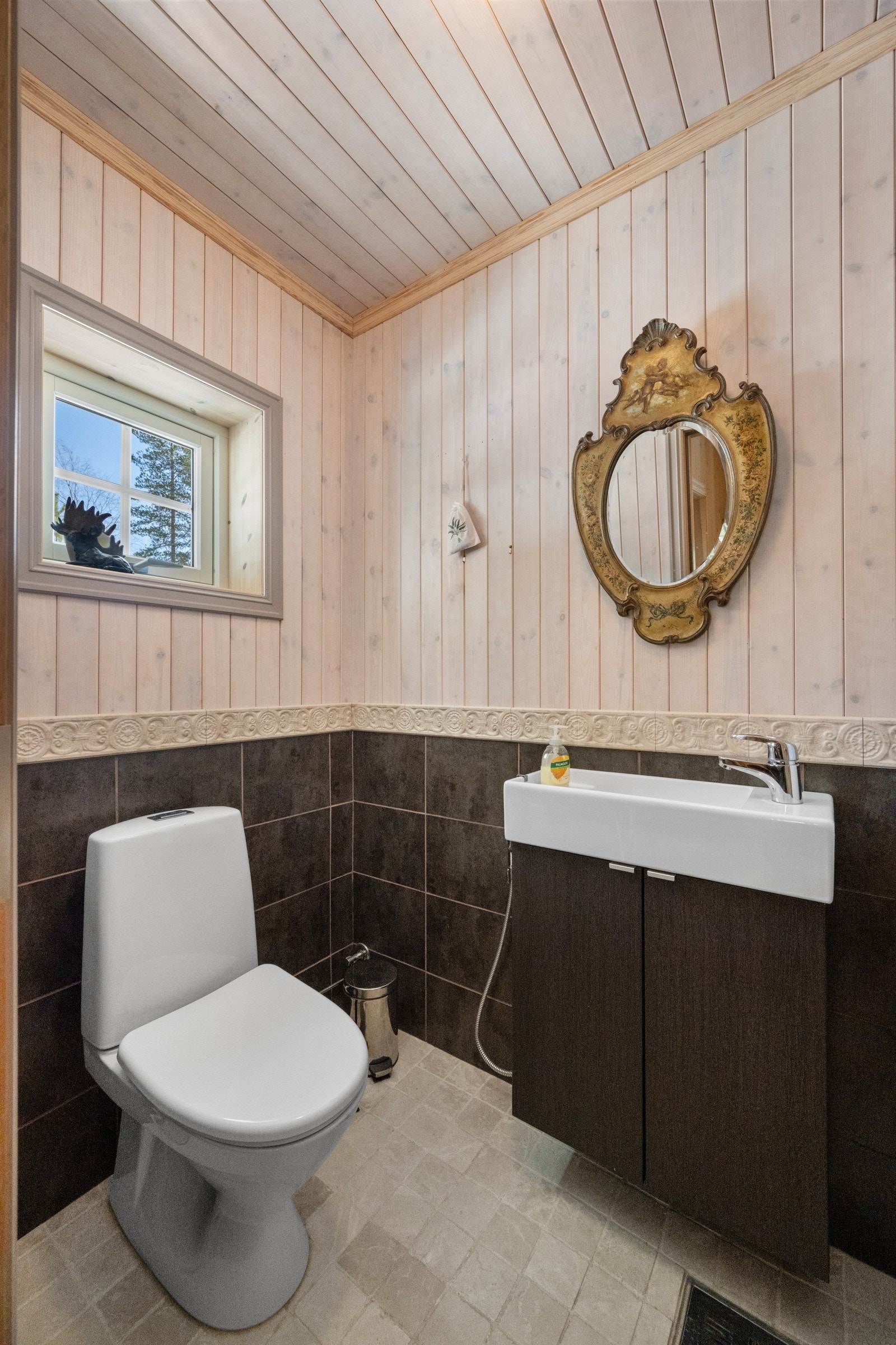 Toalettrom med overflater av fliser på gulv og panel på vegger. Varme i gulvet. Galleribilde