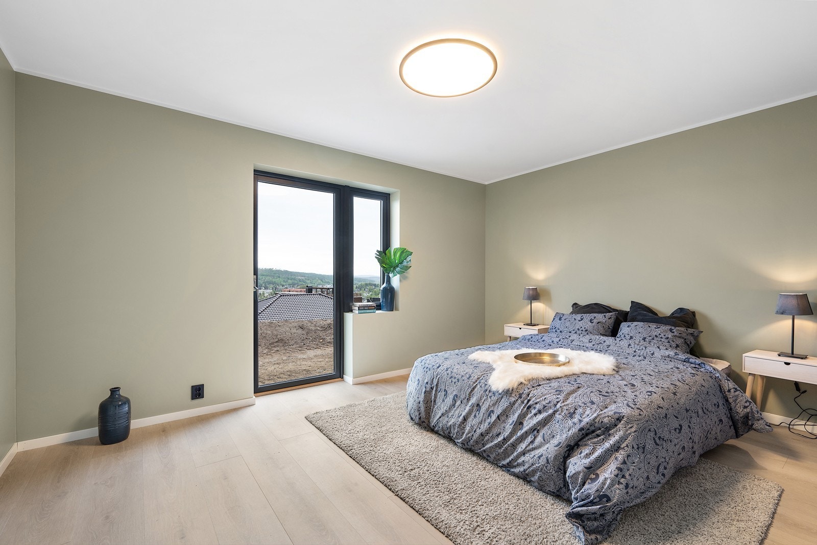 Fra ett av soverommene i første etasje er det terrassedør ut til hage. Galleribilde