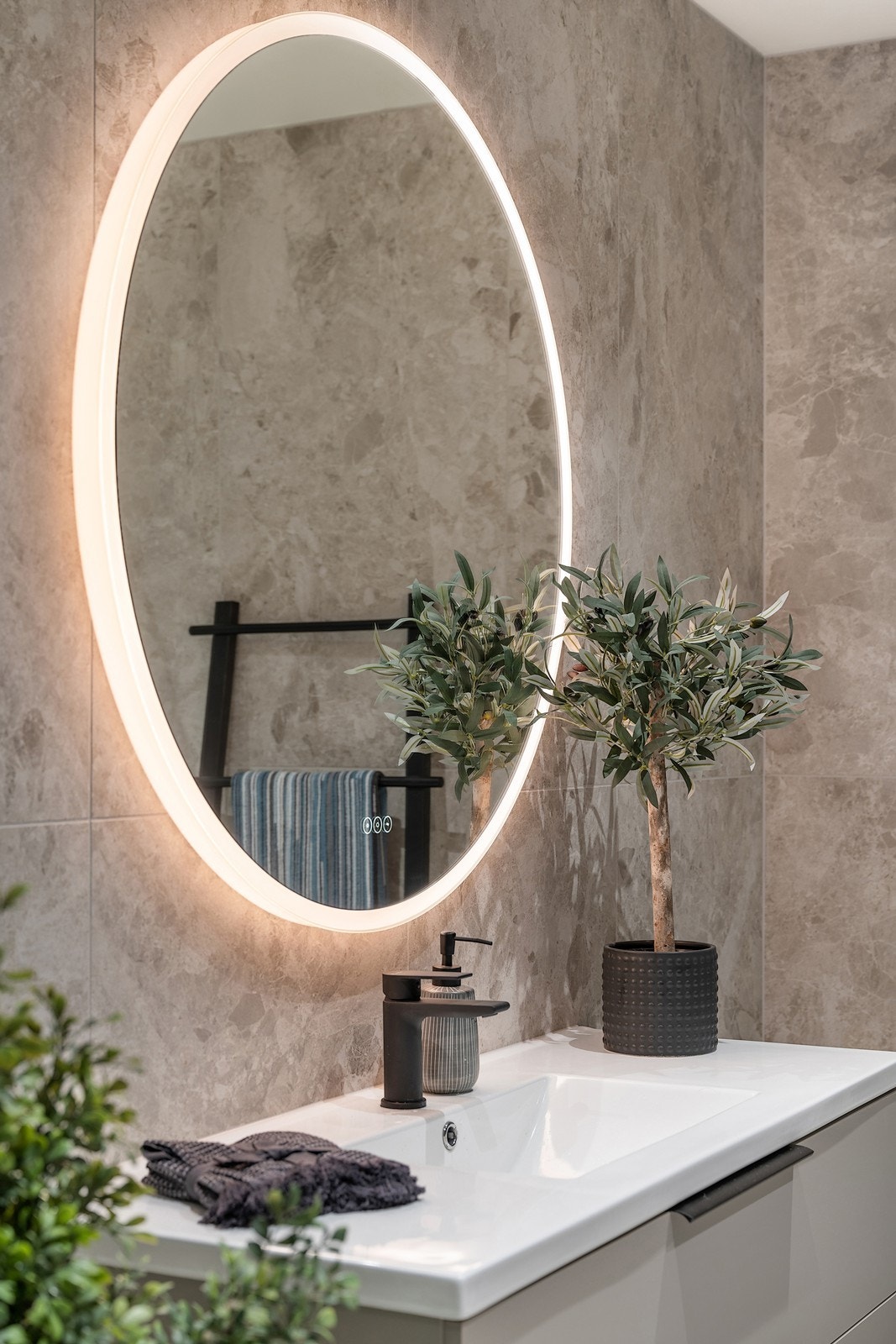 Videre har badet Geberit Monolith vegghengt toalett og et rundt speil med LED lysramme. Galleribilde