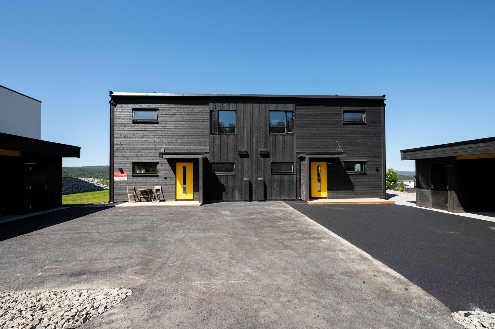 Tomannsboligen har felles gårdsplass, men hver sin carport med sportsbod. Galleribilde