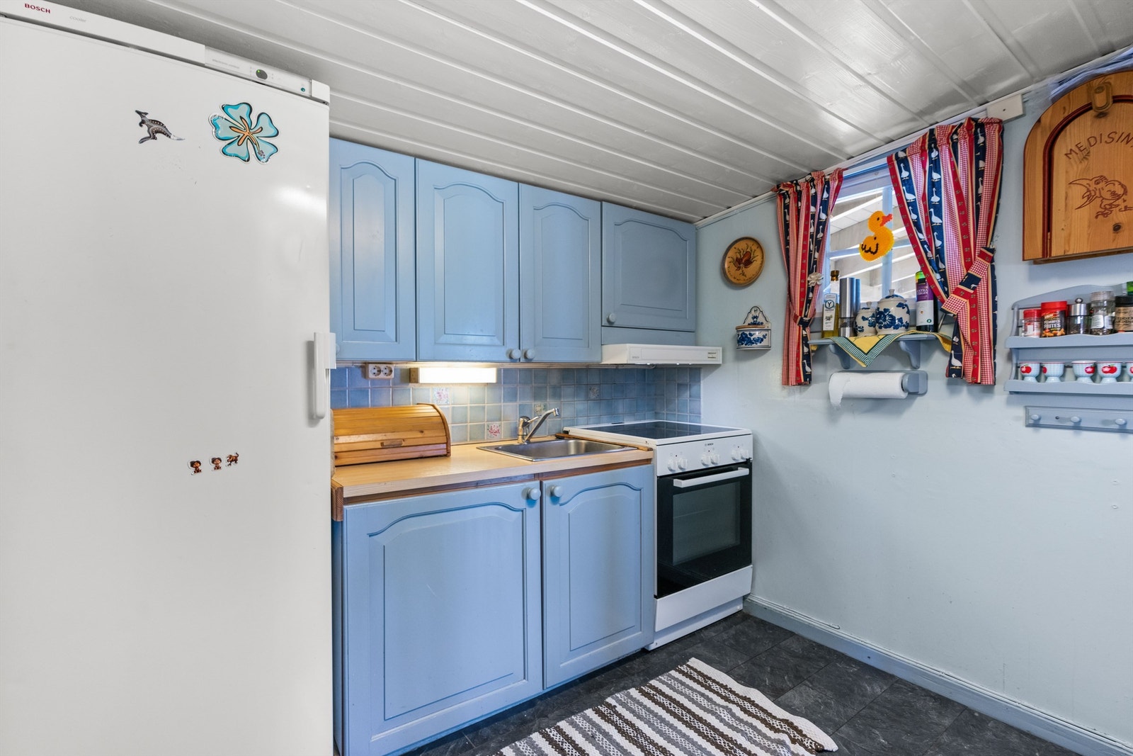 Kjøkkenet har malt innredning av heltre som er av eldre årgang, men funksjonell. Galleribilde