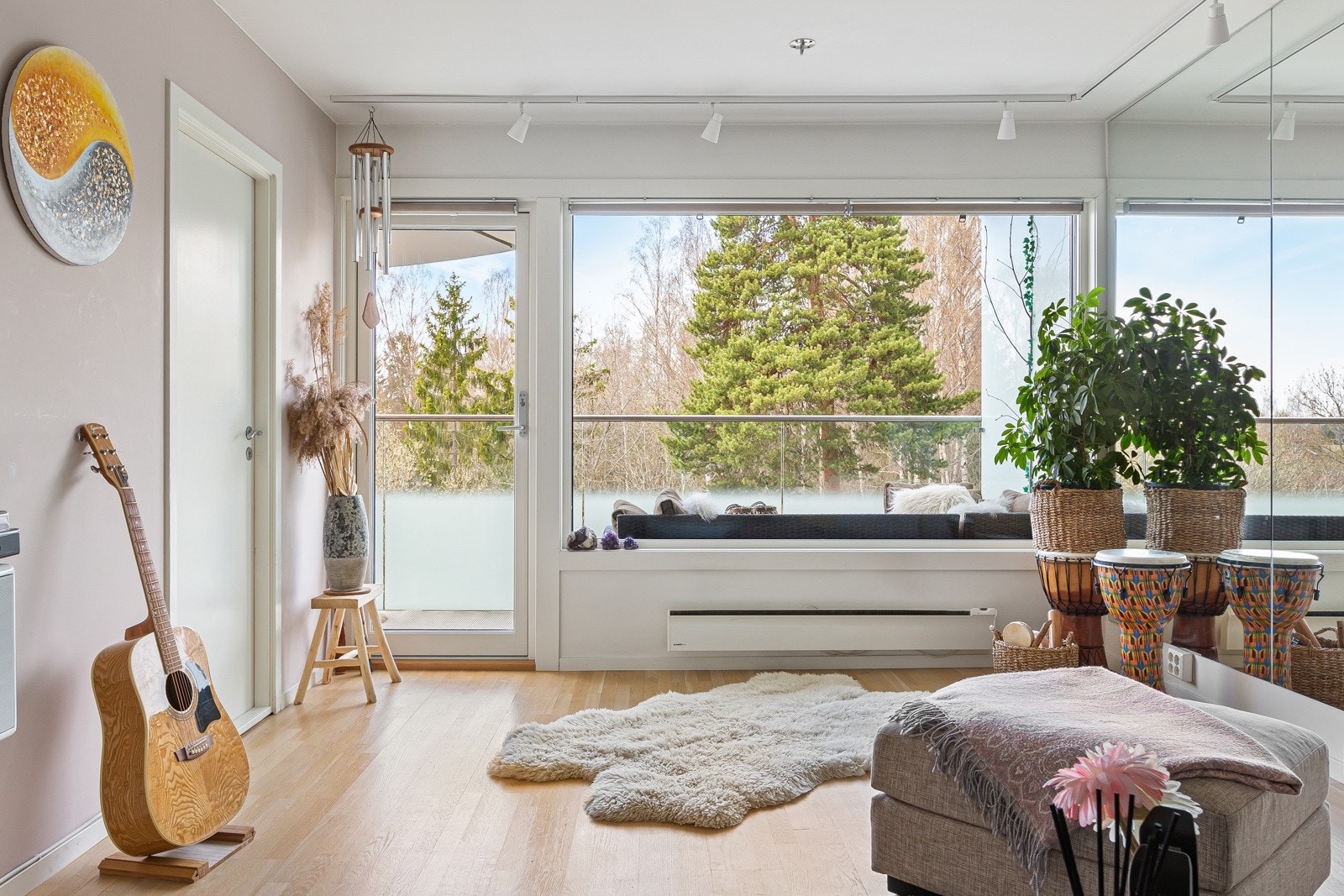 Store vindusflater på endeveggen i stuen har sikrer behagelige lysforhold. Vinduer og balkongdør er fra 2019. Galleribilde