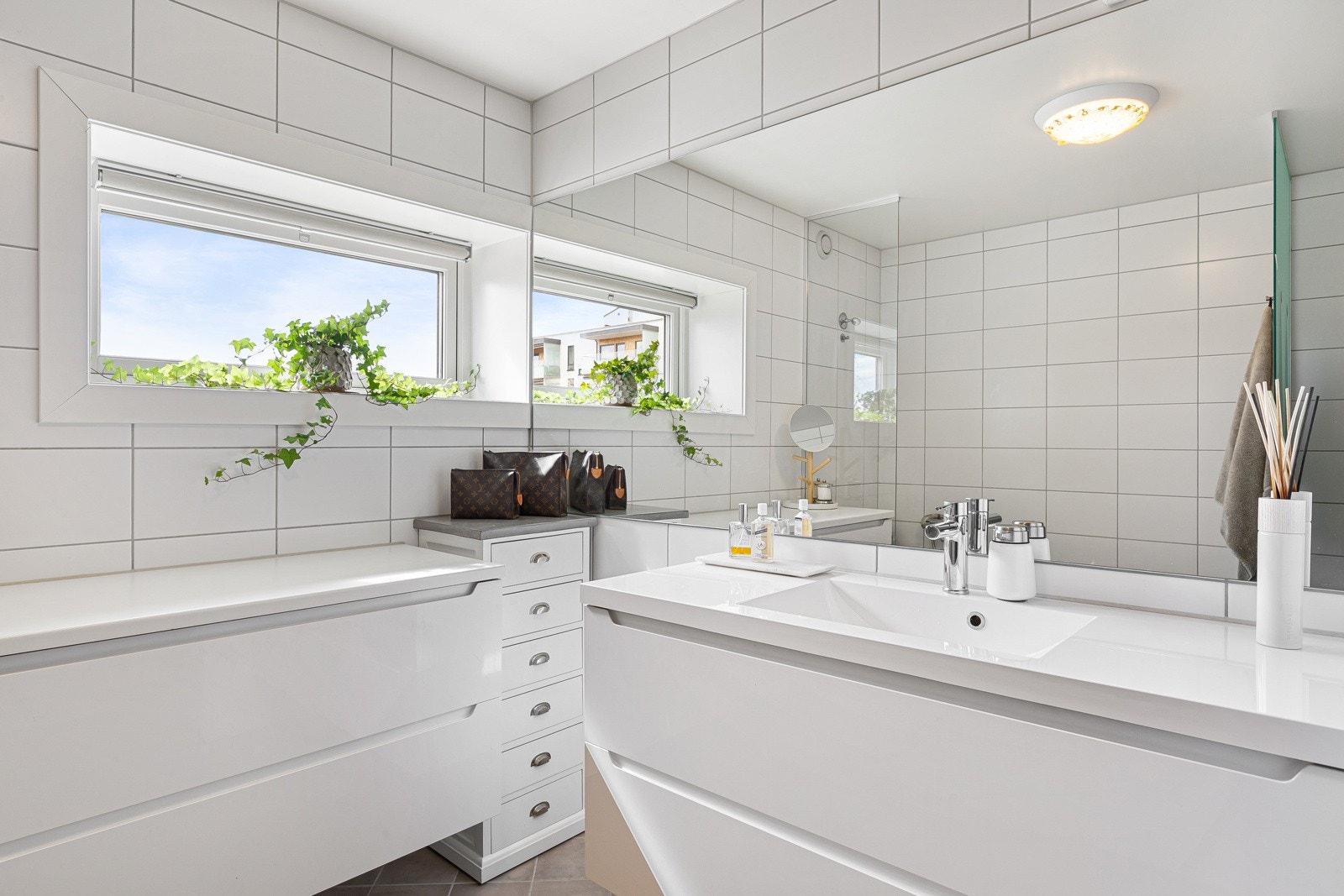 Innredningen er i moderne design og har hvite, høyglans fronter, heldekkende servant og stort speil. Galleribilde