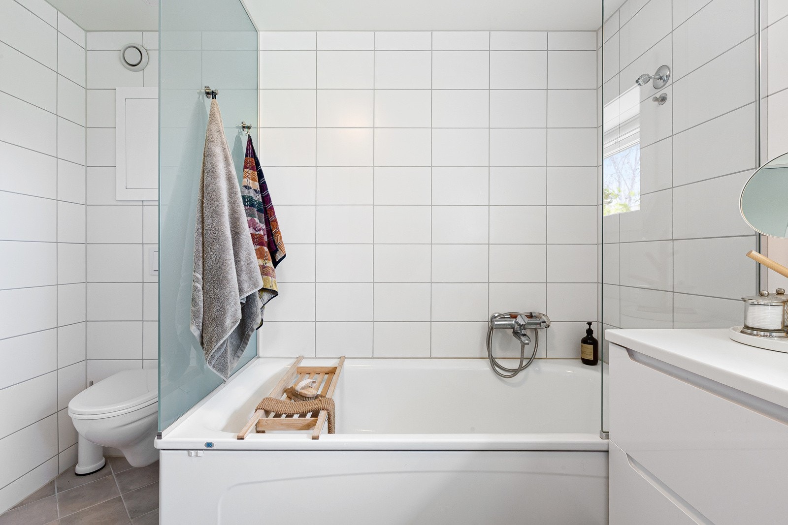 Badet er utstyrt med både veggmontert toalett og badekar med dusjvegger. Galleribilde