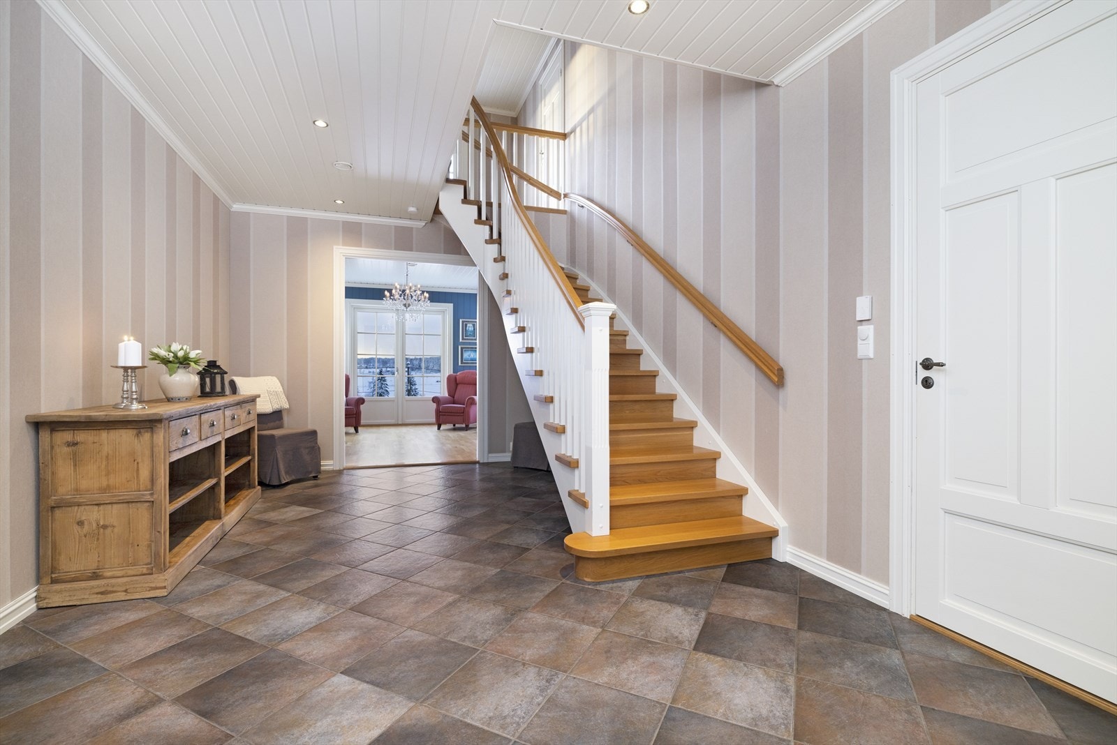 Romslig trappehall med flislagt gulv og downlights i himling. Galleribilde