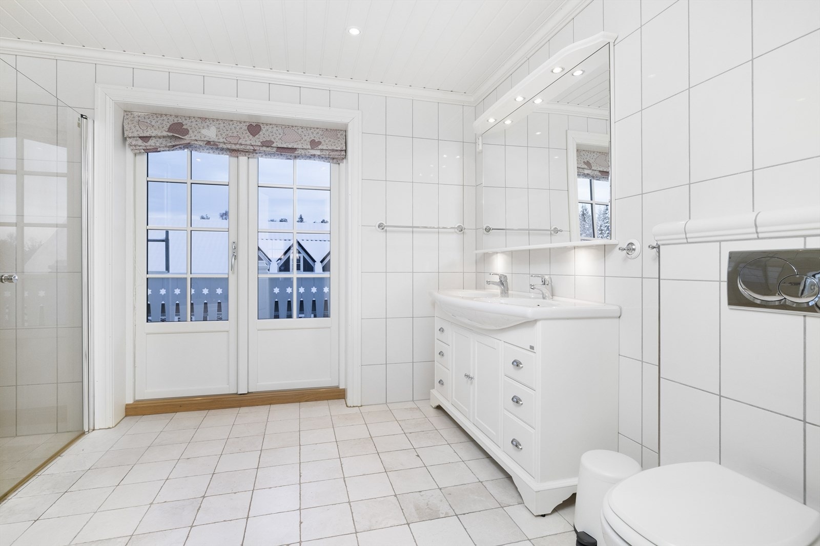 Badet er innredet med vegghengt toalett, dobbel servant, boblebad og dusjnisje. Galleribilde