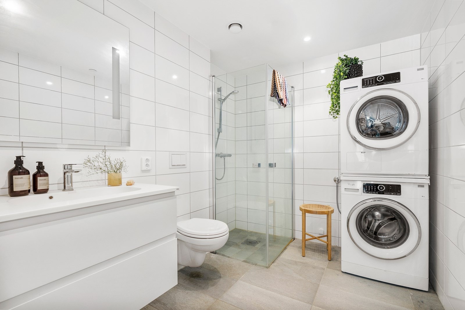 Badet er delikat og helfliset med naturflis. God plass til møblement i tillegg til servantskapet. Vegghengt toalett og dusjdører i glass. Opplegg til vaskemaskin og tørketrommel. Galleribilde