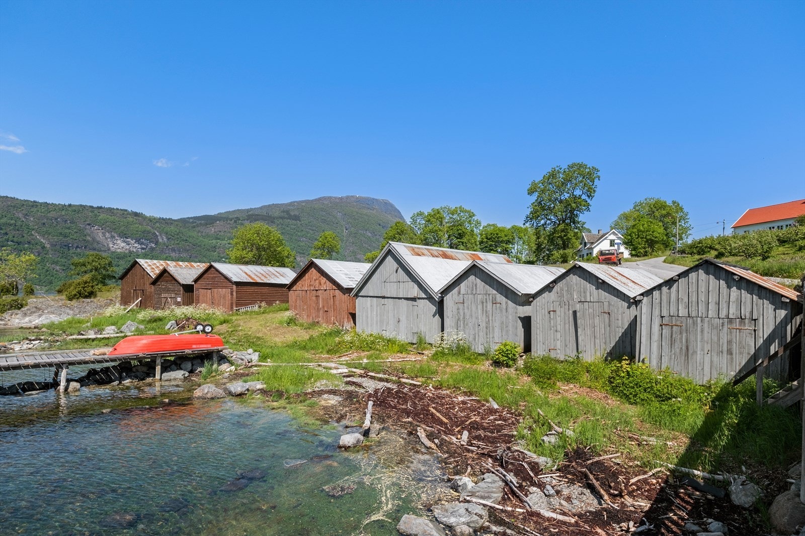 Naust ved kaien med båt som føl med i handelen. Galleribilde