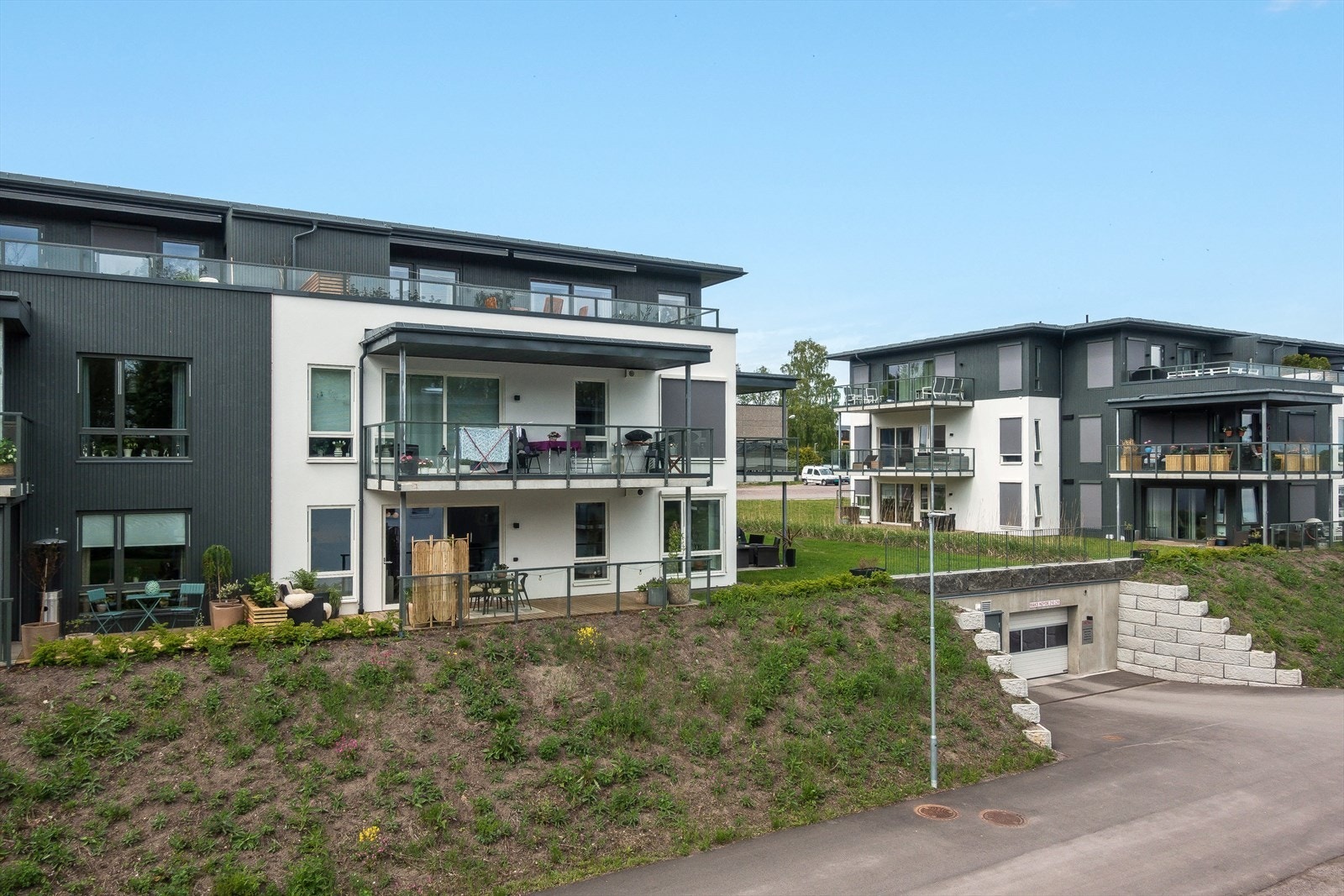 Fasade, leilighet i senter av bilde, kjøreport til garasjeanlegg nede til høyre i bildet. Galleribilde