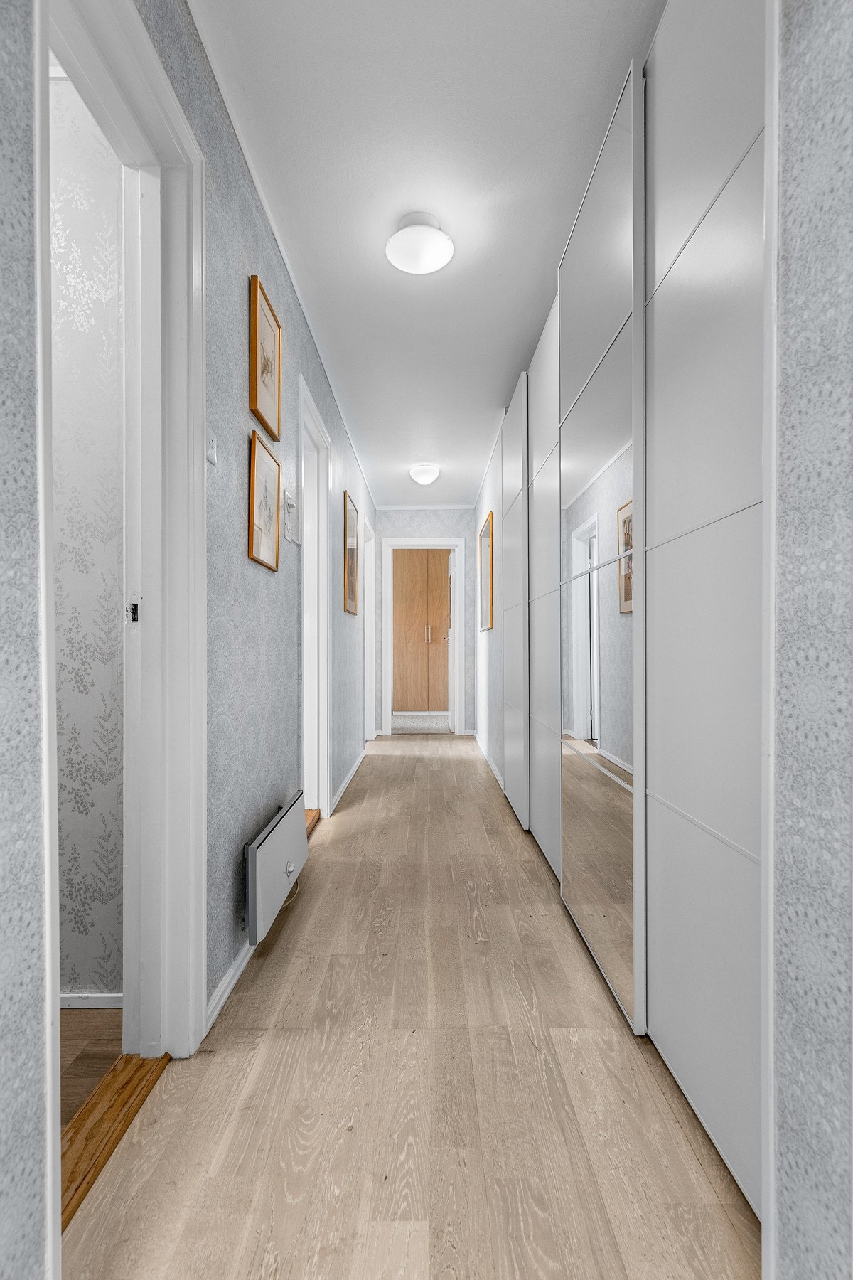 Gang med praktisk skyvedørsgarderobe med god plass til å henge fra seg klær og andre ting. Galleribilde
