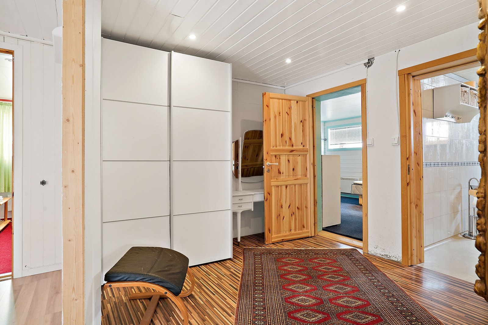 Gang mellom bad og soverom med monterte spotter i himling, samt skyvedørsgarderobe. Galleribilde