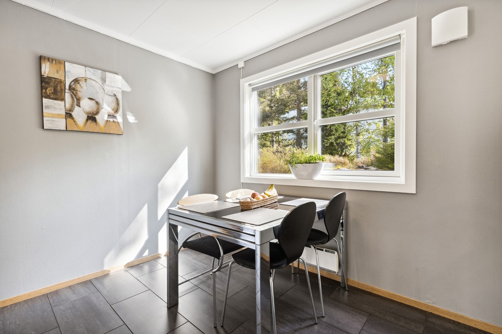 Vinduet fyller rommet med dagslys og lar deg nyte utsikten over den delvise frodige hagen og delvise naturtomten utenfor. Det er god plass for en spisegruppe. Galleribilde