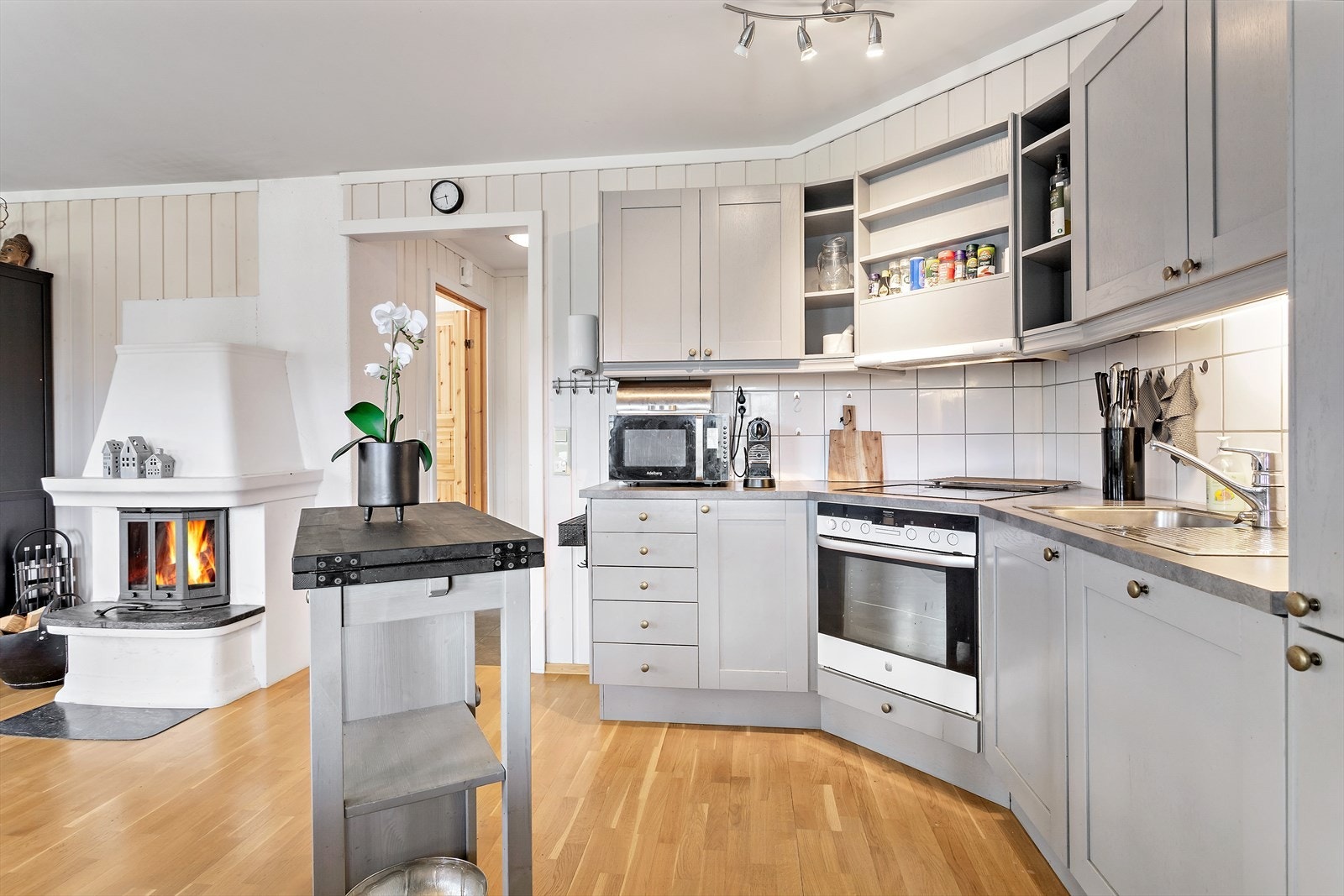 Kjøkkeninnredning med profilerte fronter og belysning under overskap Galleribilde