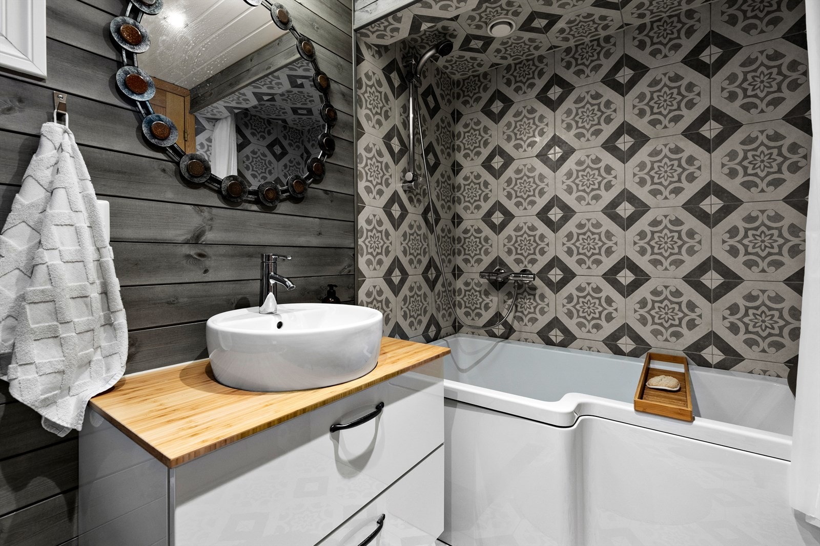 Badet er innredet med veggmontert wc og badekar med ettgreps dusjbatteri i rustfritt stål fra grohe Galleribilde