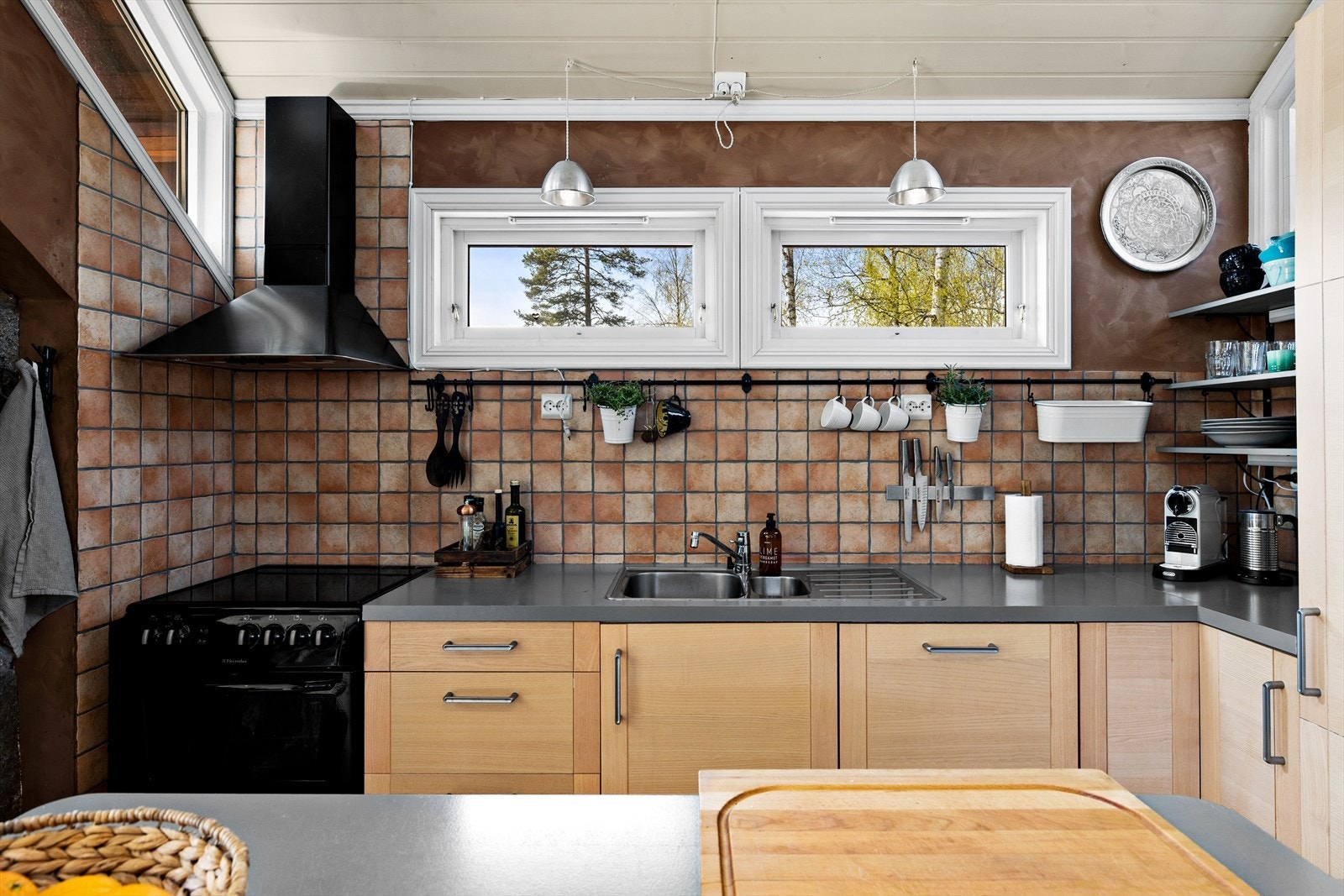 Kjøkken med profilerte og finér-fronter. Det er integrert oppvaskmaskin og kjøleskap og opplegg for komfyr Galleribilde