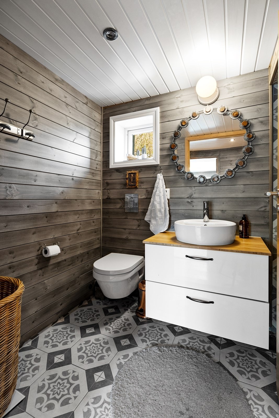 Bredt servantskap med glatte og hvite og høyglanslaminerte fronter av spon, benkeplate i bambus med overmontert hvit og keramisk enkel servant med ettgreps blandebatteri i rustfritt stål Galleribilde