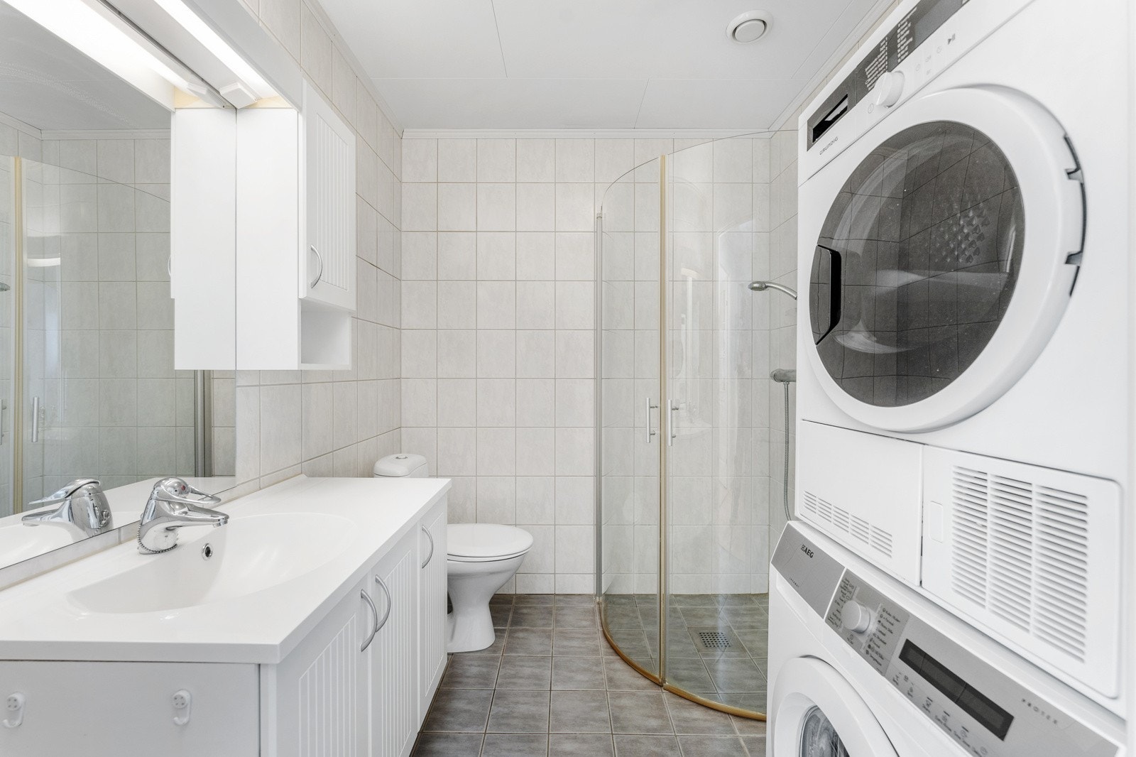 Bad med wc, dusjhjørnet og opplegg til vaskemaskin Galleribilde