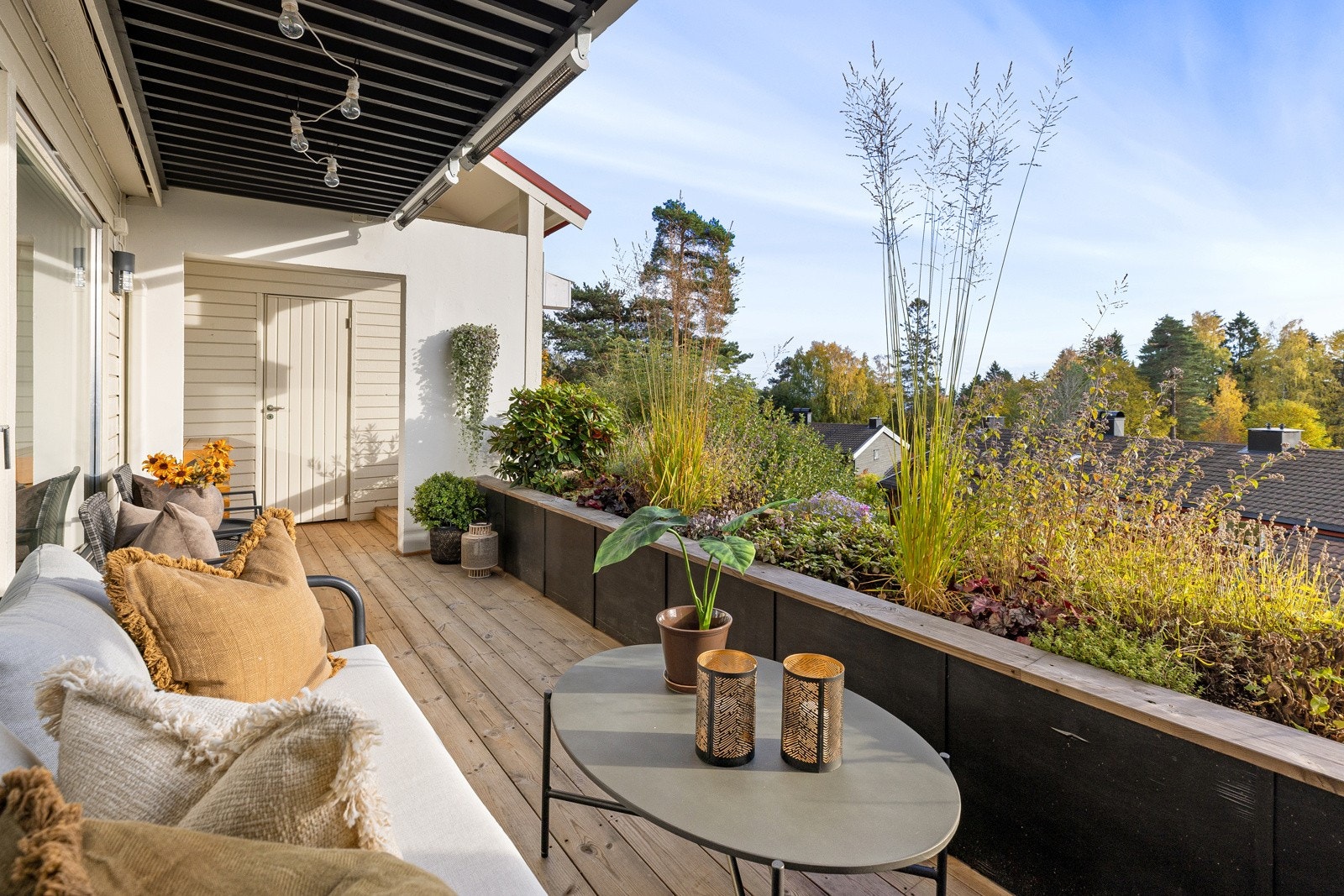 Solrik og sydvendt terrasse som er delvis overbygget på ca. 16,5 kvm inkl. innvendig bod med furu terrassebord på dekke fra 2021 og hyggelig utsyn over nærområdet. Galleribilde