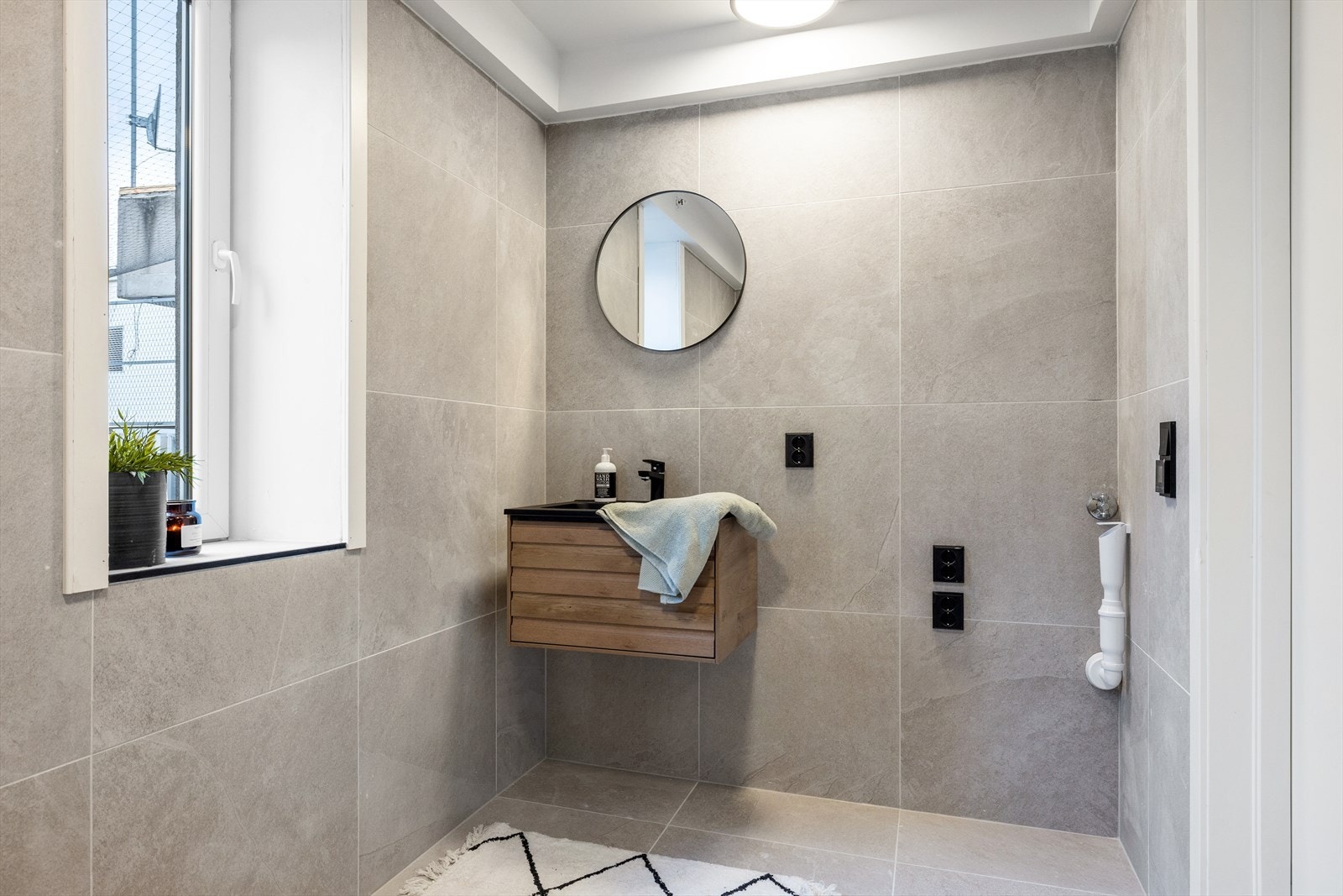 På badet er det dusjnisje, vegghengt toalett, servant med innredning og opplegg for vaskerom Galleribilde