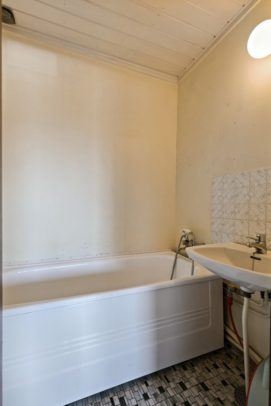 Badet ligger vegg i vegg og er innredet med badekar og servant. Galleribilde