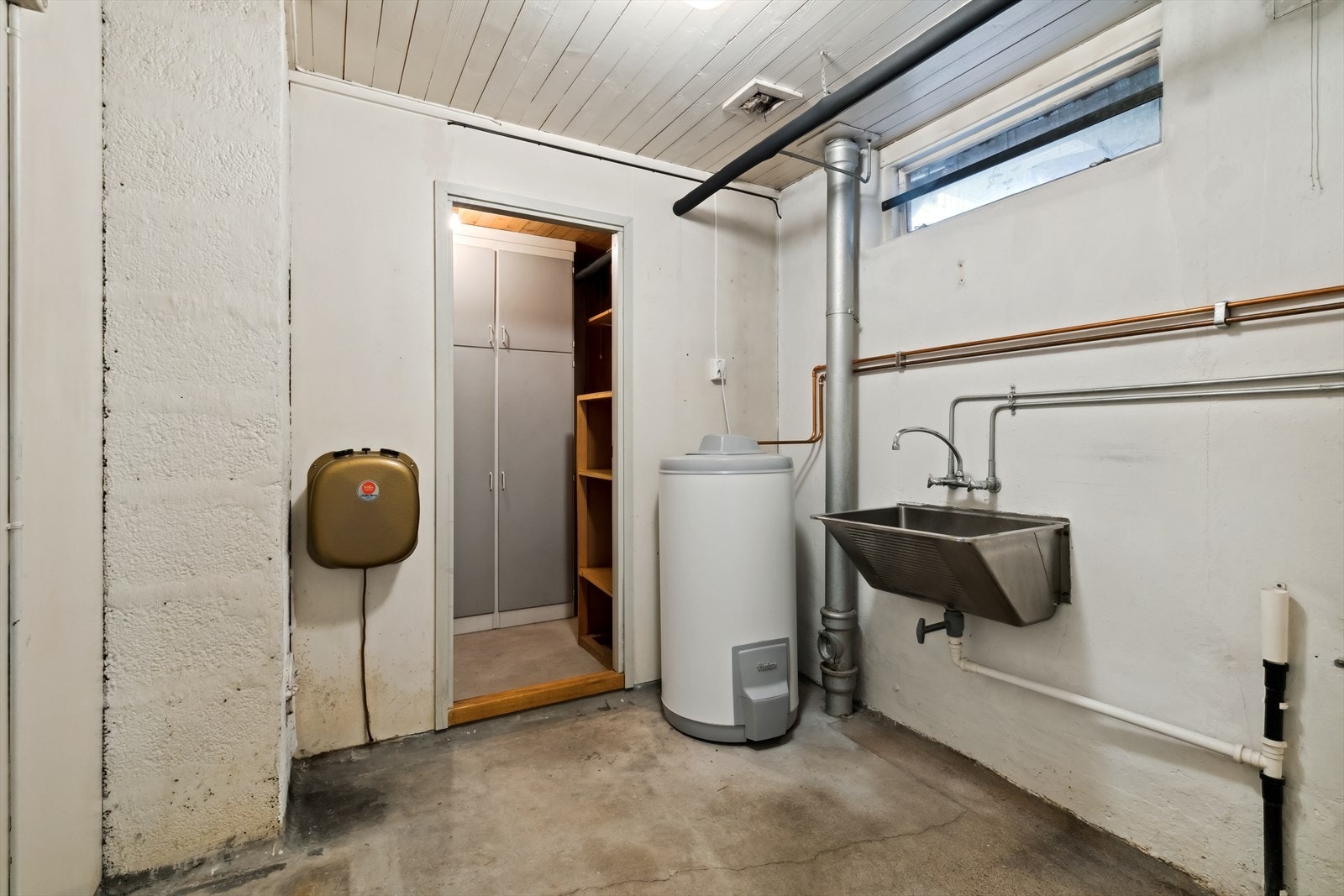 Vaskerom innredet med skyllekum og opplegg for vaskemaskin. Galleribilde